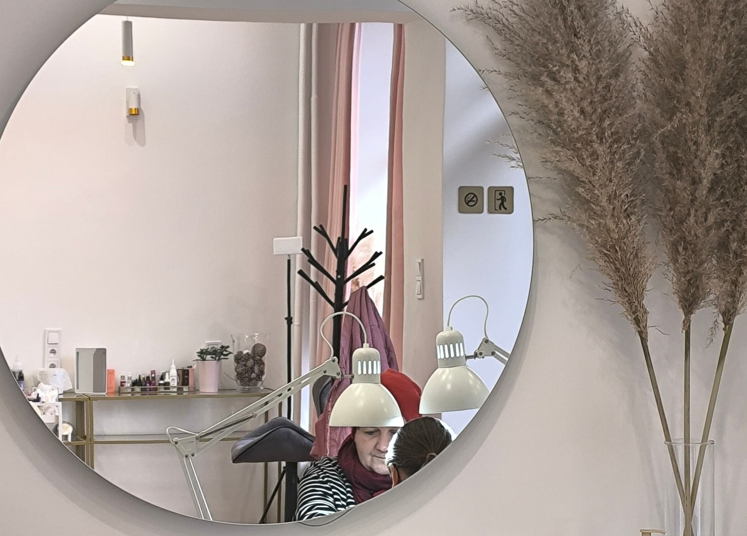 Eleganckie wnętrze SUGAR Lashes & Brows w Kraków, Województwo Małopolskie, PL, z okrągłym lustrem i dekoracjami.