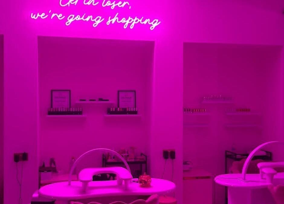 Chic neon-lit interior of The Nail Rituals in Exeter, England, GB with stylish nail stations.