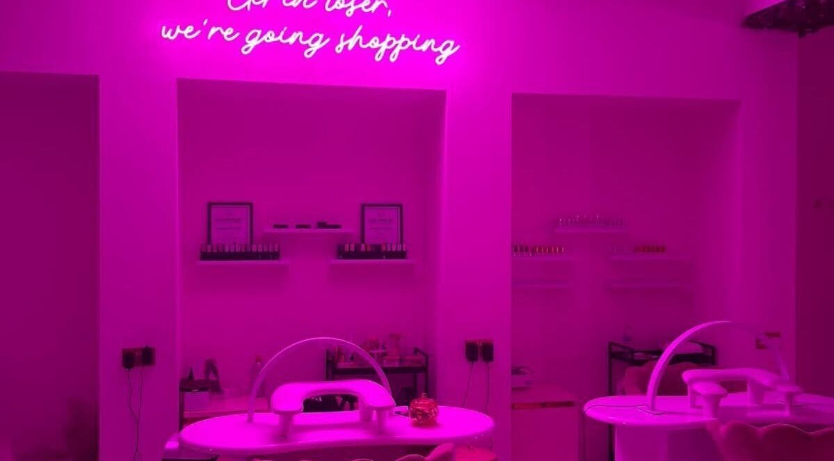 Chic neon-lit interior of The Nail Rituals in Exeter, England, GB with stylish nail stations.