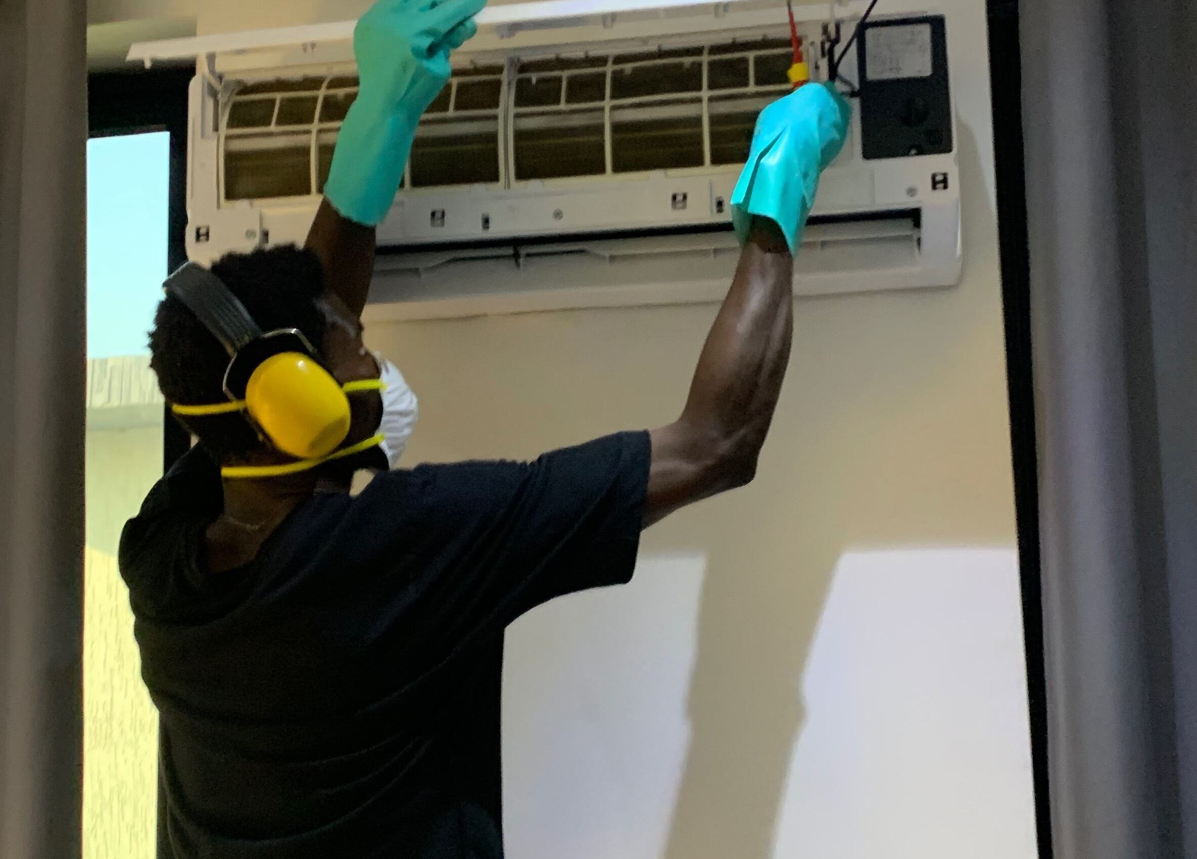 Technician servicing AC unit at Chillboss AC.Services, Adenta Municipality, Greater Accra Region, GH.