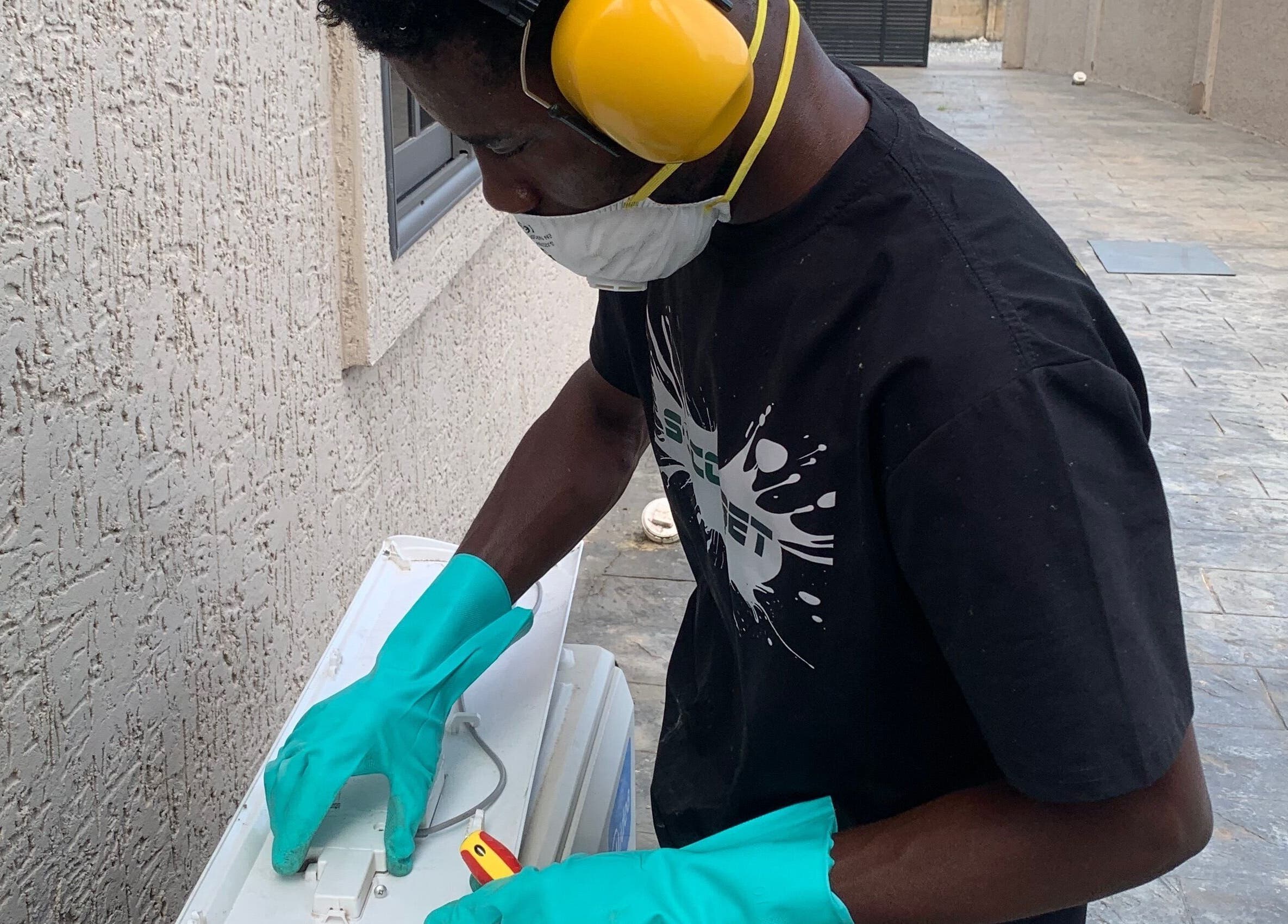 Technician servicing AC unit at Chillboss AC.Services, Adenta Municipality, Greater Accra Region, GH.