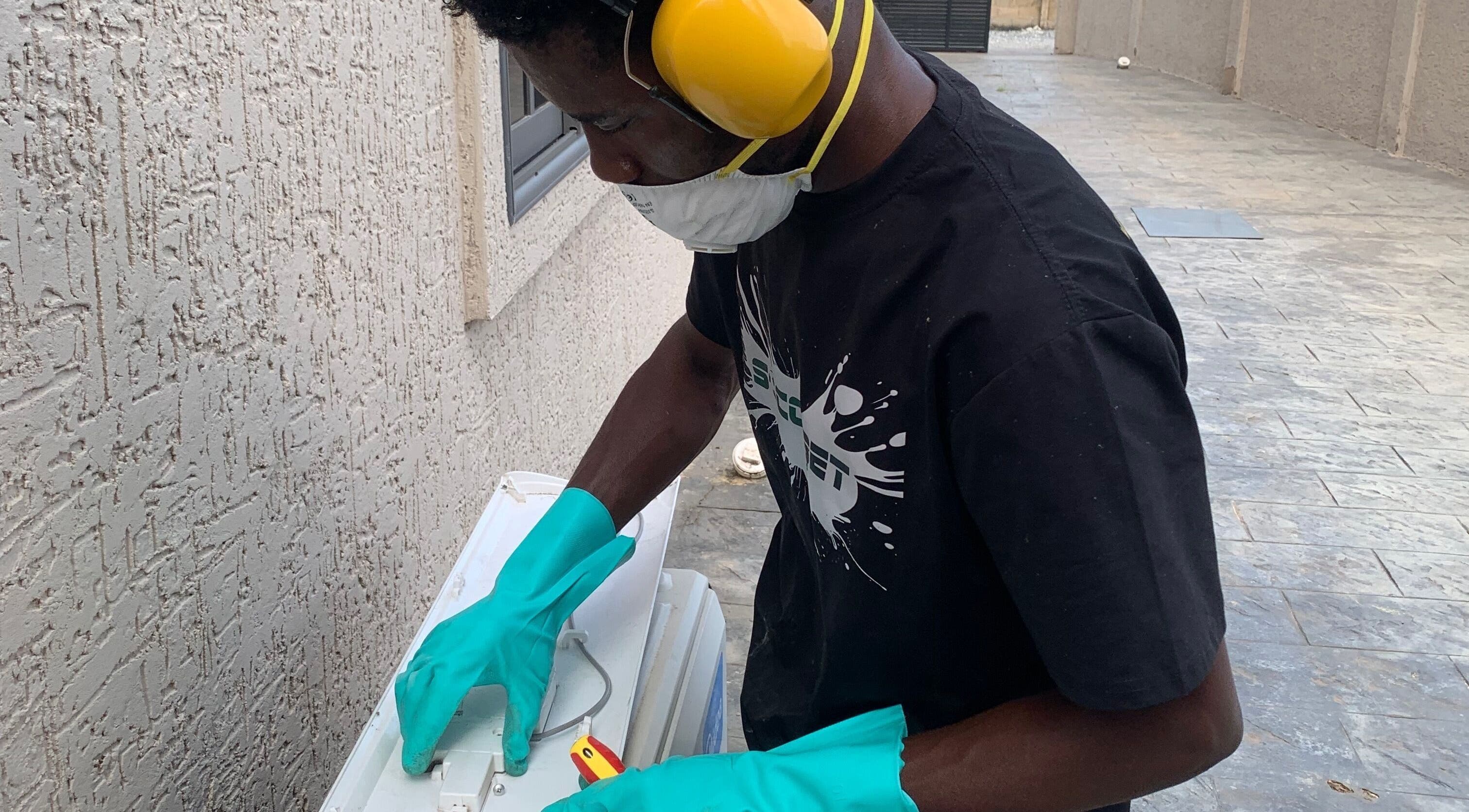 Technician servicing AC unit at Chillboss AC.Services, Adenta Municipality, Greater Accra Region, GH.