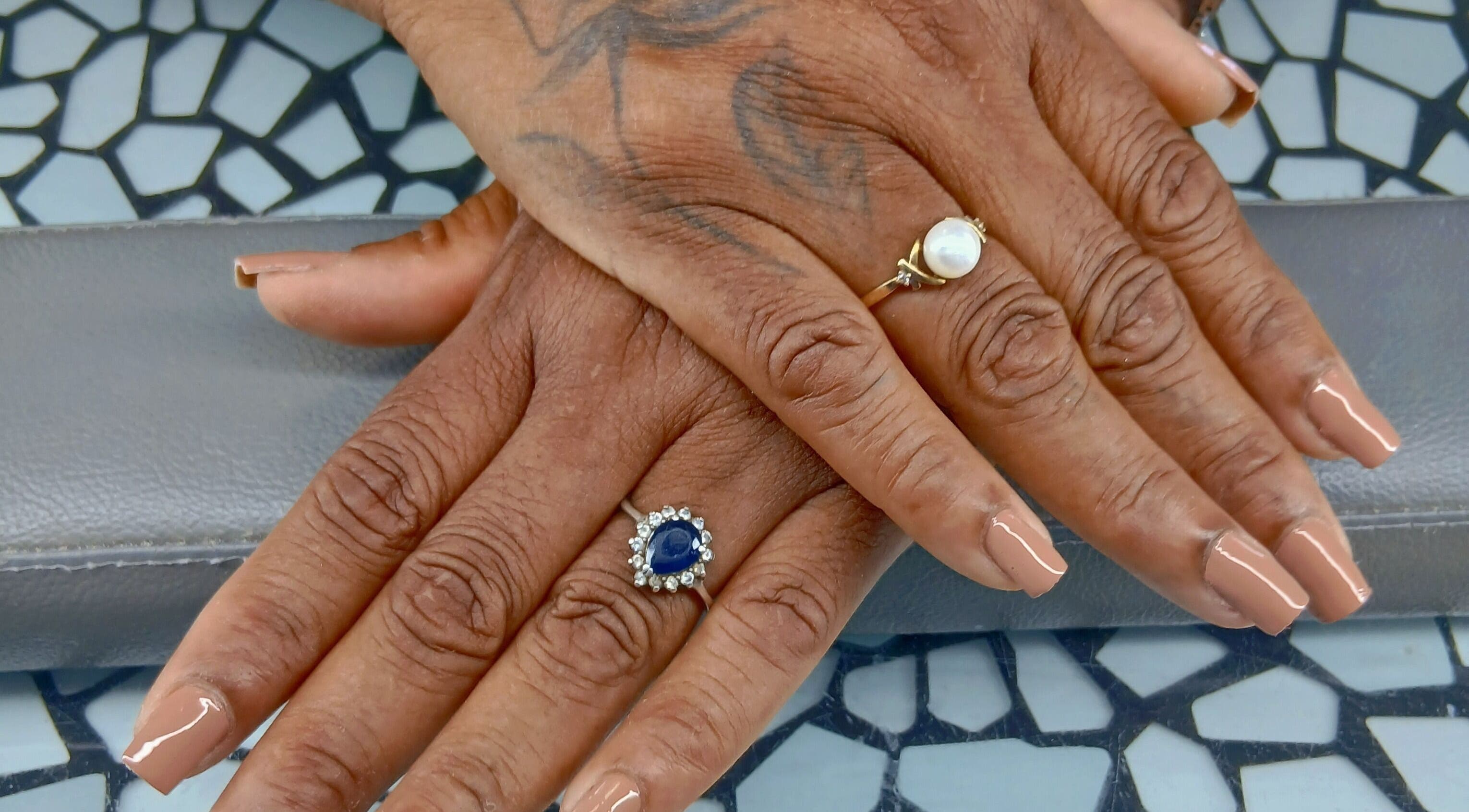 Stylish manicure with nude polish and rings at Golden Phoenix Nails, Koolbaai, Sint Maarten, SX.