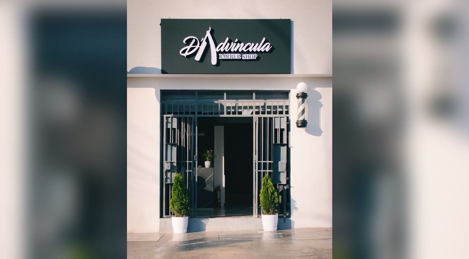 Entrada de D' Advincula Barbershop en San Juan De Miraflores, Provincia De Lima, PE, con plantas decorativas.