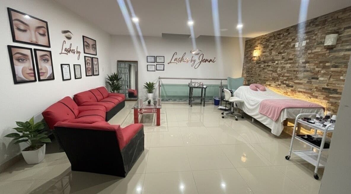 Interior acogedor de JR Beauty Co. en Ocotlán, Tlaxcala, MX, con sofás rojos y cabina de estética.