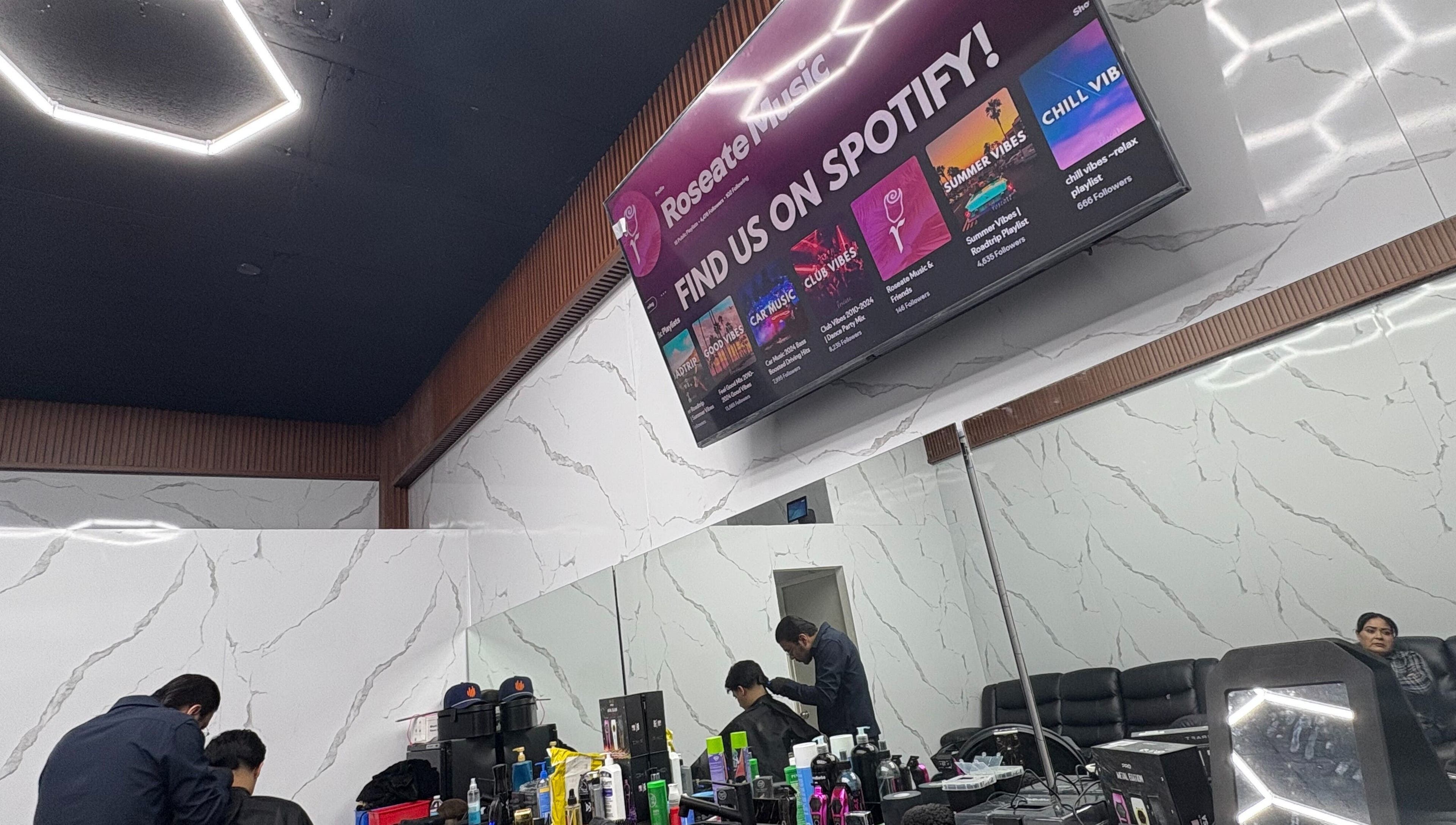 Interior moderno de Barberia del Patron en Hermosillo, Sonora, MX con estante de productos y espejo amplio.