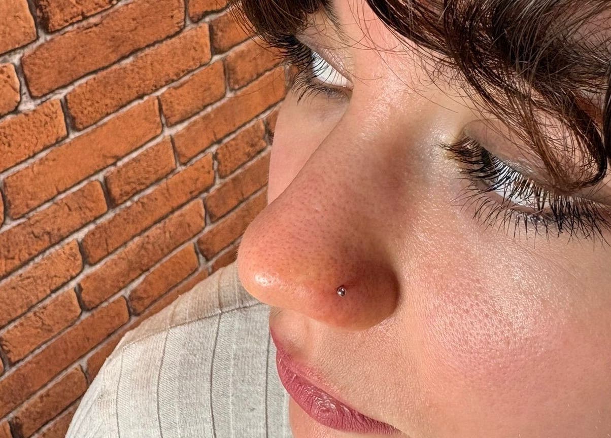 Piercing au nez chez HaloRoom Piercing, Gometz-la-ville, Île-de-france, FR, devant mur de briques.