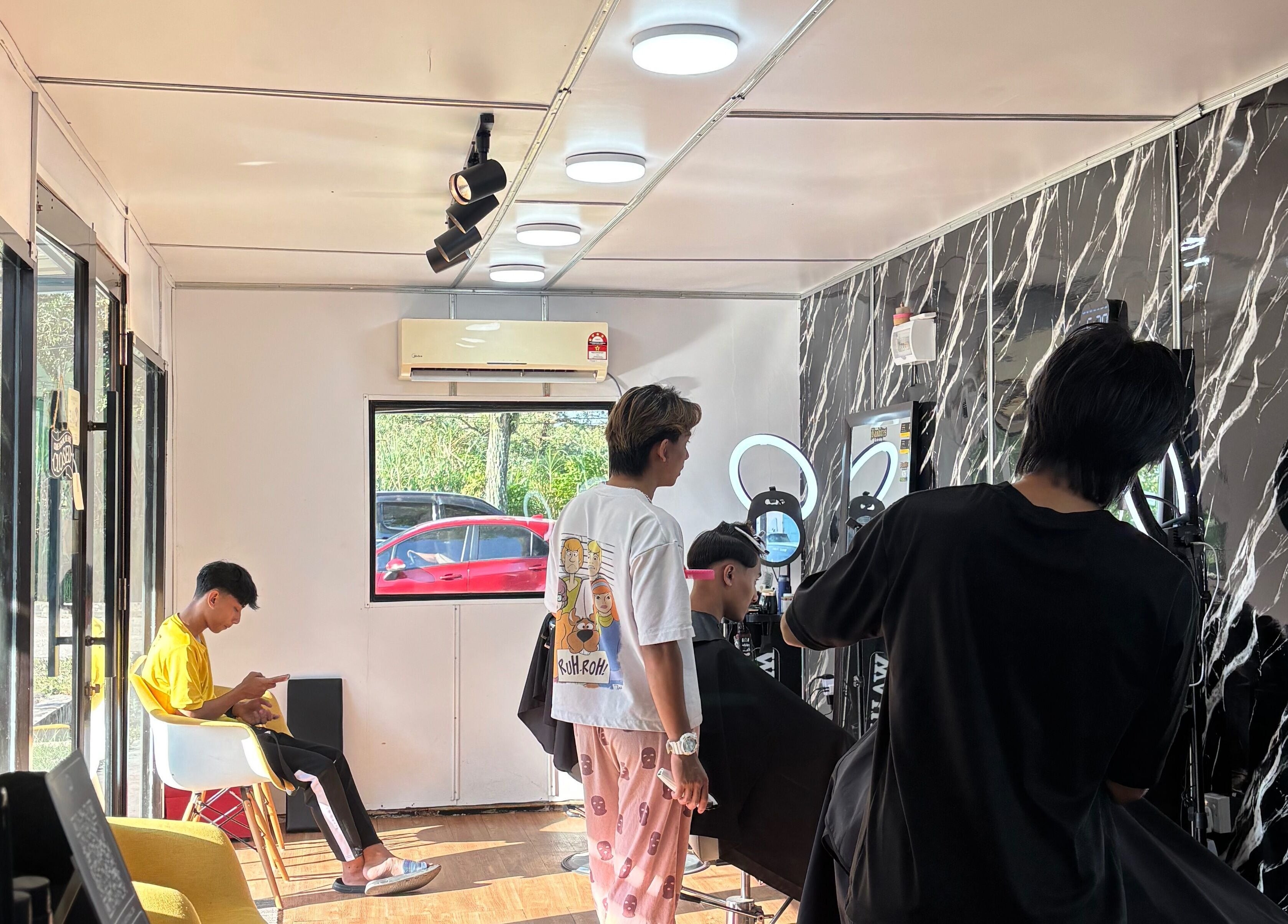 Inside Banditos Barbershop, Kulai, Johor Darul Ta'zim, MY. A customer gets a haircut in the modern, bright interior.