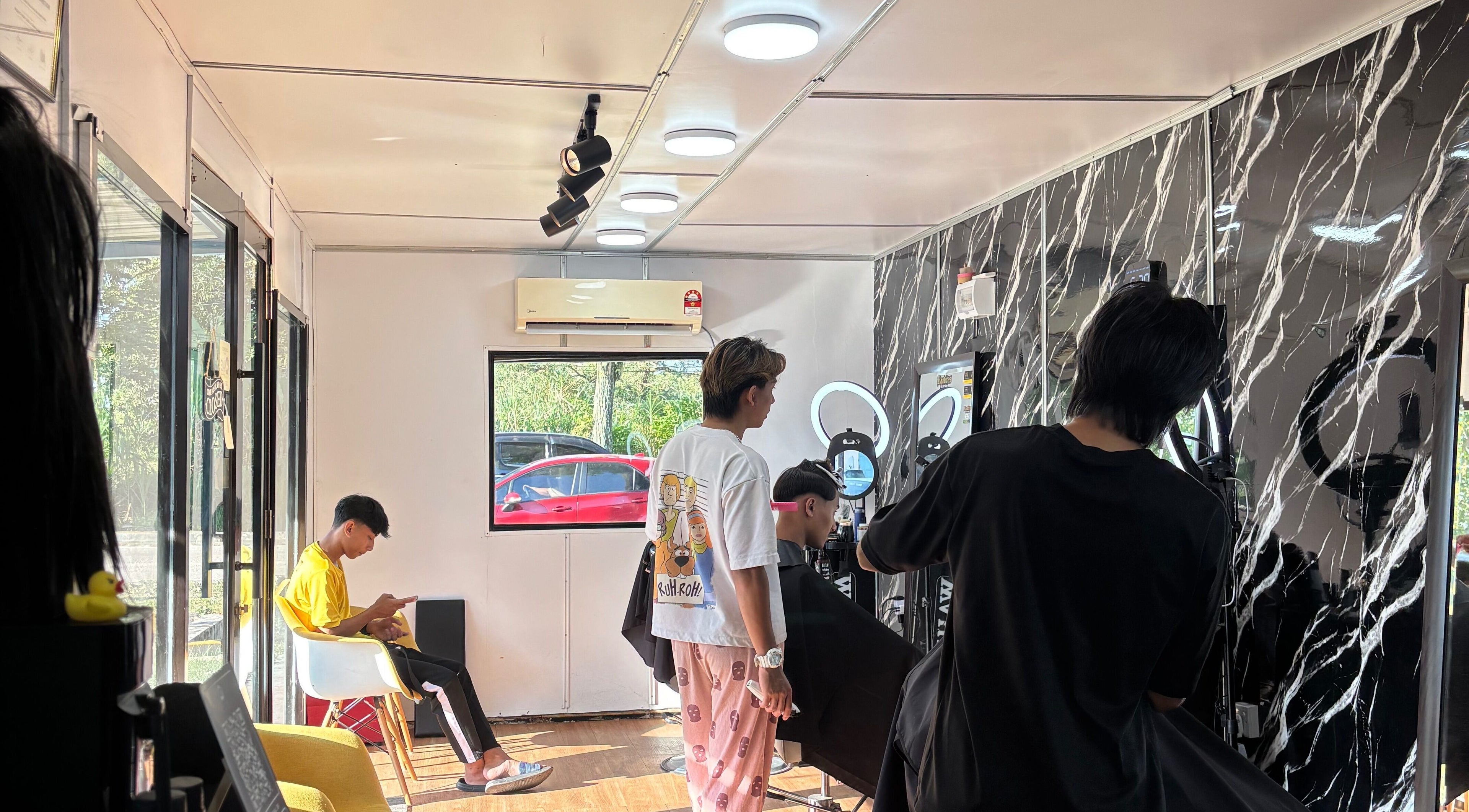 Inside Banditos Barbershop, Kulai, Johor Darul Ta'zim, MY. A customer gets a haircut in the modern, bright interior.