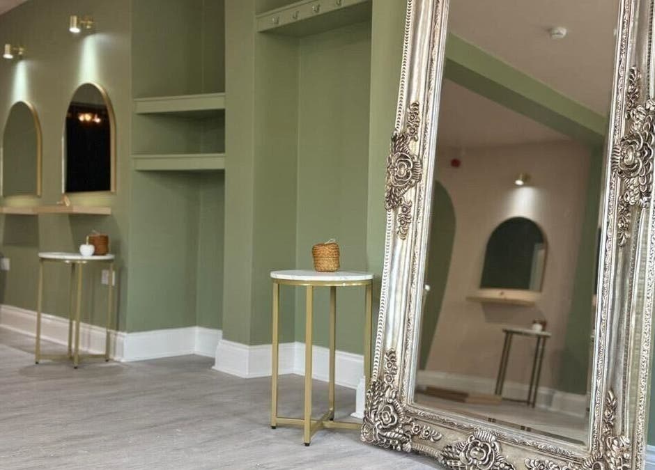 Chic interior of Red Rabbit Barber in Langley Moor, England, GB with ornate mirror and green walls.