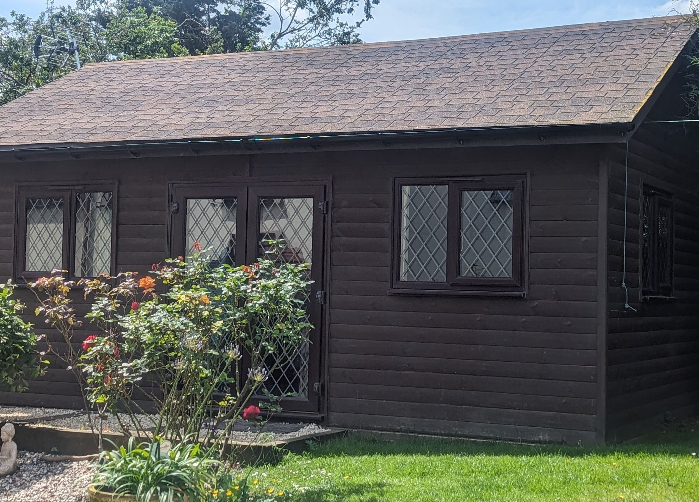 The Cabin's picturesque exterior in Black Notley, England, GB with lush greenery and rustic charm.