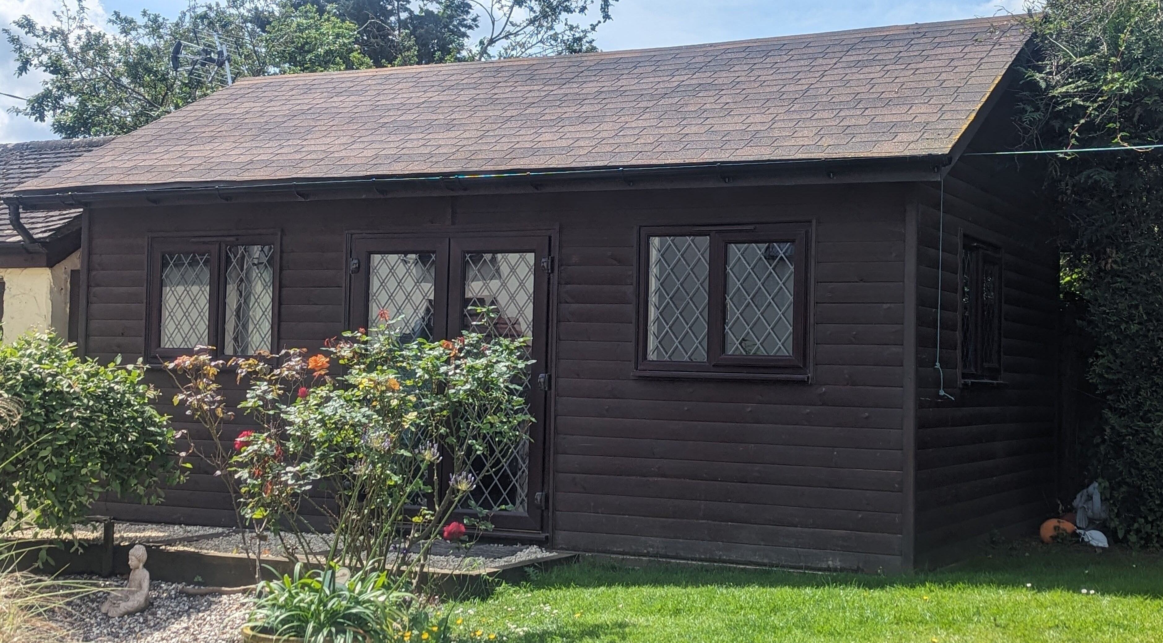 The Cabin's picturesque exterior in Black Notley, England, GB with lush greenery and rustic charm.