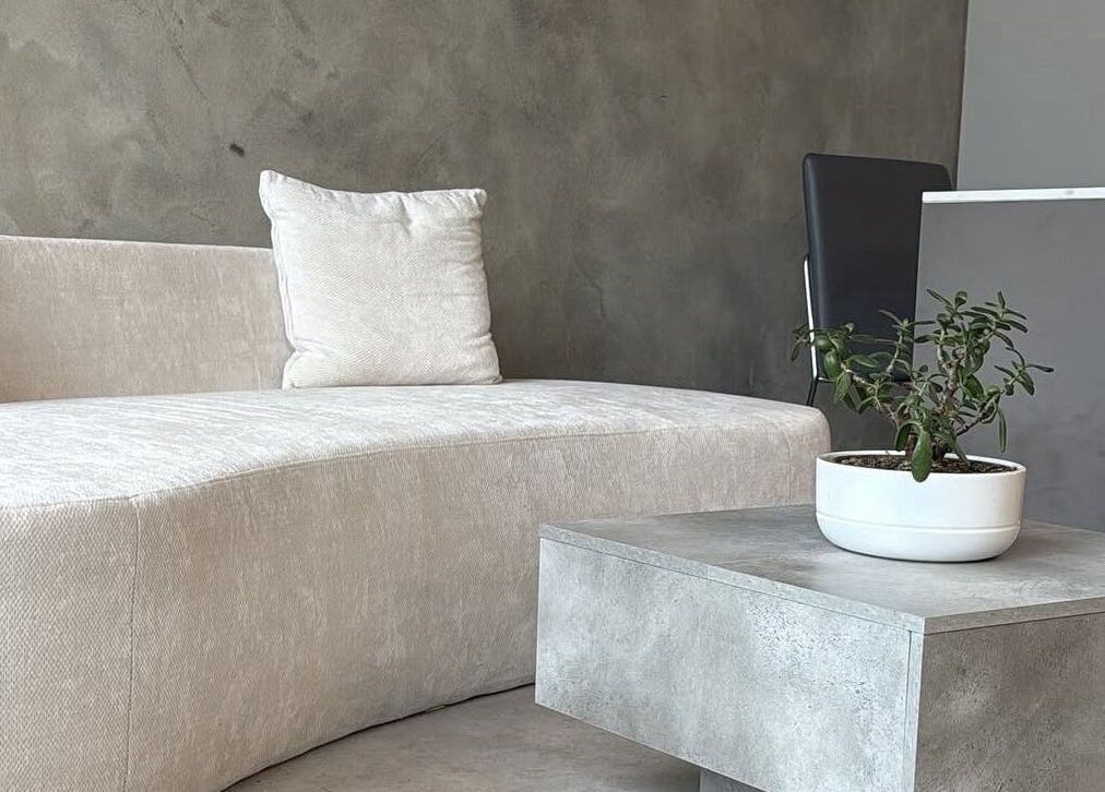 Elegant waiting area at Mundy Grooming, London, England, GB featuring a cozy sofa and modern decor.