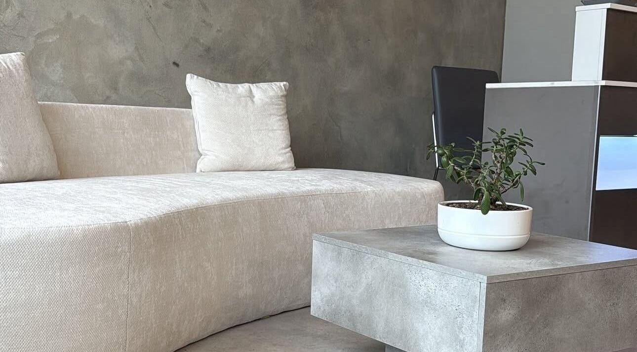 Elegant waiting area at Mundy Grooming, London, England, GB featuring a cozy sofa and modern decor.