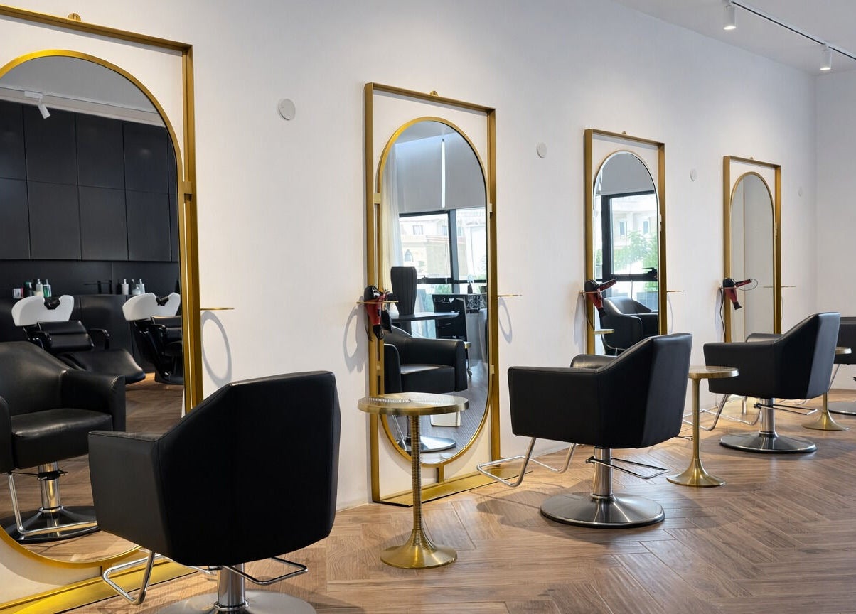 Stylish salon interior at Mariage Beauty Center in Abu Dhabi, AE, featuring modern black chairs and gold mirrors.