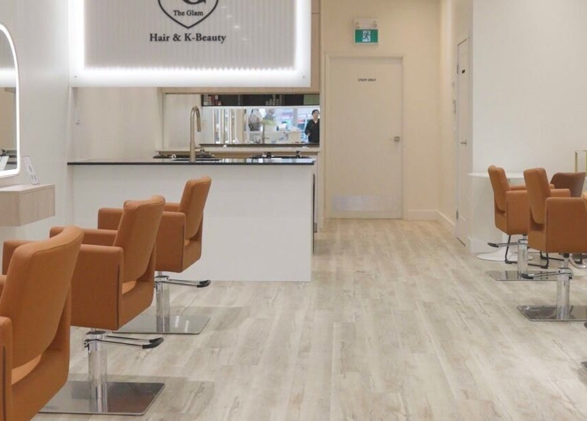Modern salon interior at The Glam Hair&K Beauty in Toronto, Ontario, CA, showcasing sleek design and seating.