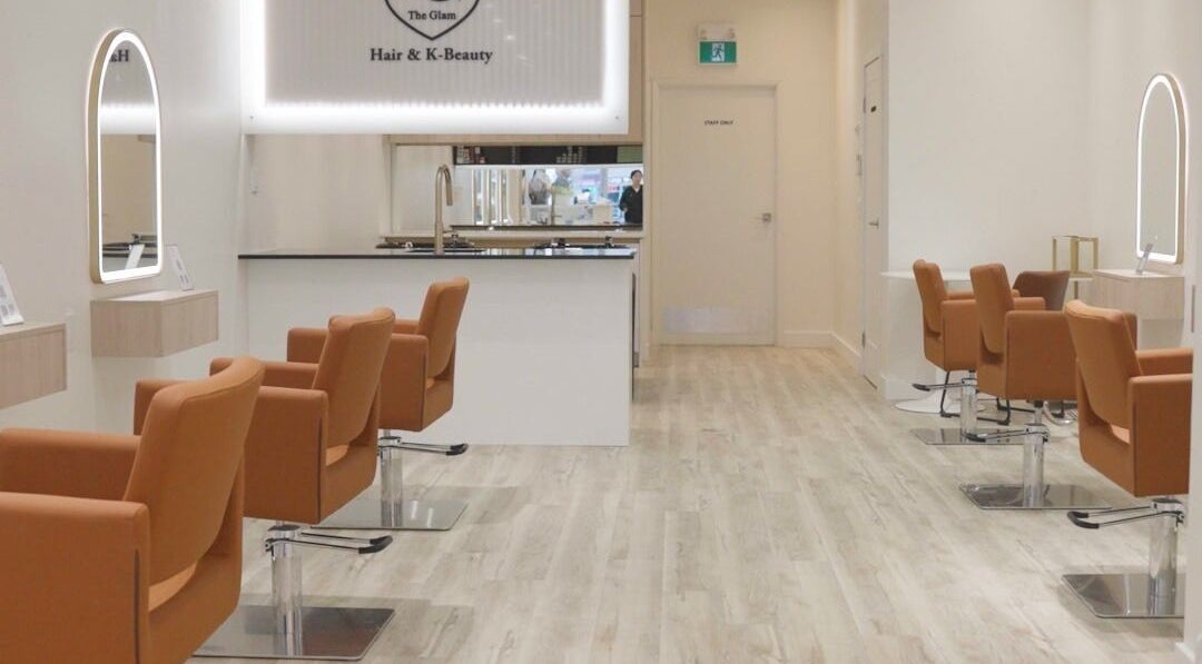 Modern salon interior at The Glam Hair&K Beauty in Toronto, Ontario, CA, showcasing sleek design and seating.