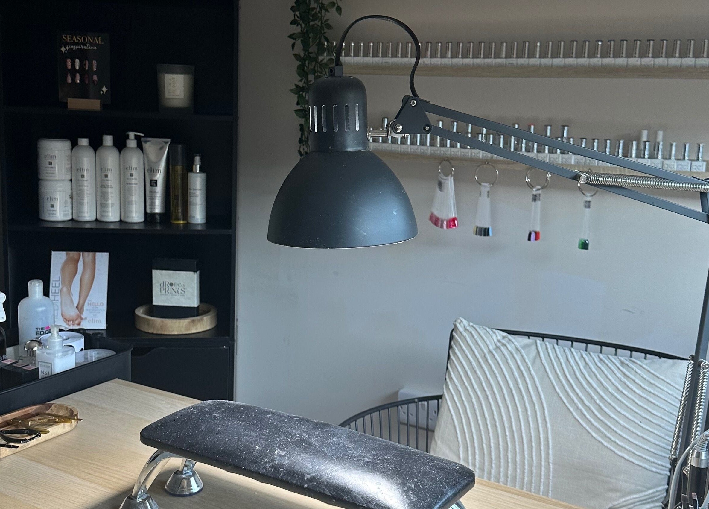 Nail care station at Shape & Gloss, Stoke-on-Trent, England, GB. Featuring a lamp and manicure tools on a table.