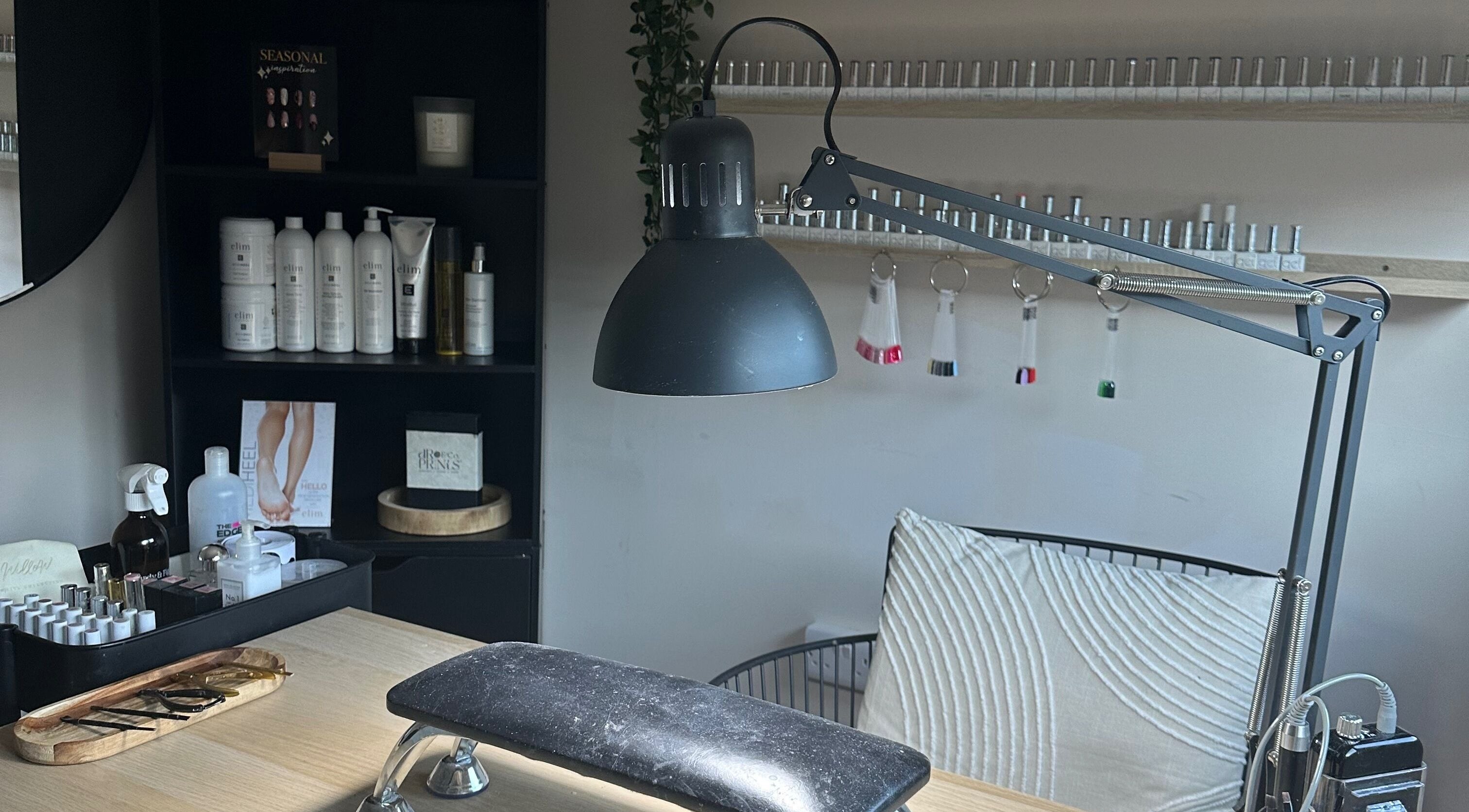 Nail care station at Shape & Gloss, Stoke-on-Trent, England, GB. Featuring a lamp and manicure tools on a table.