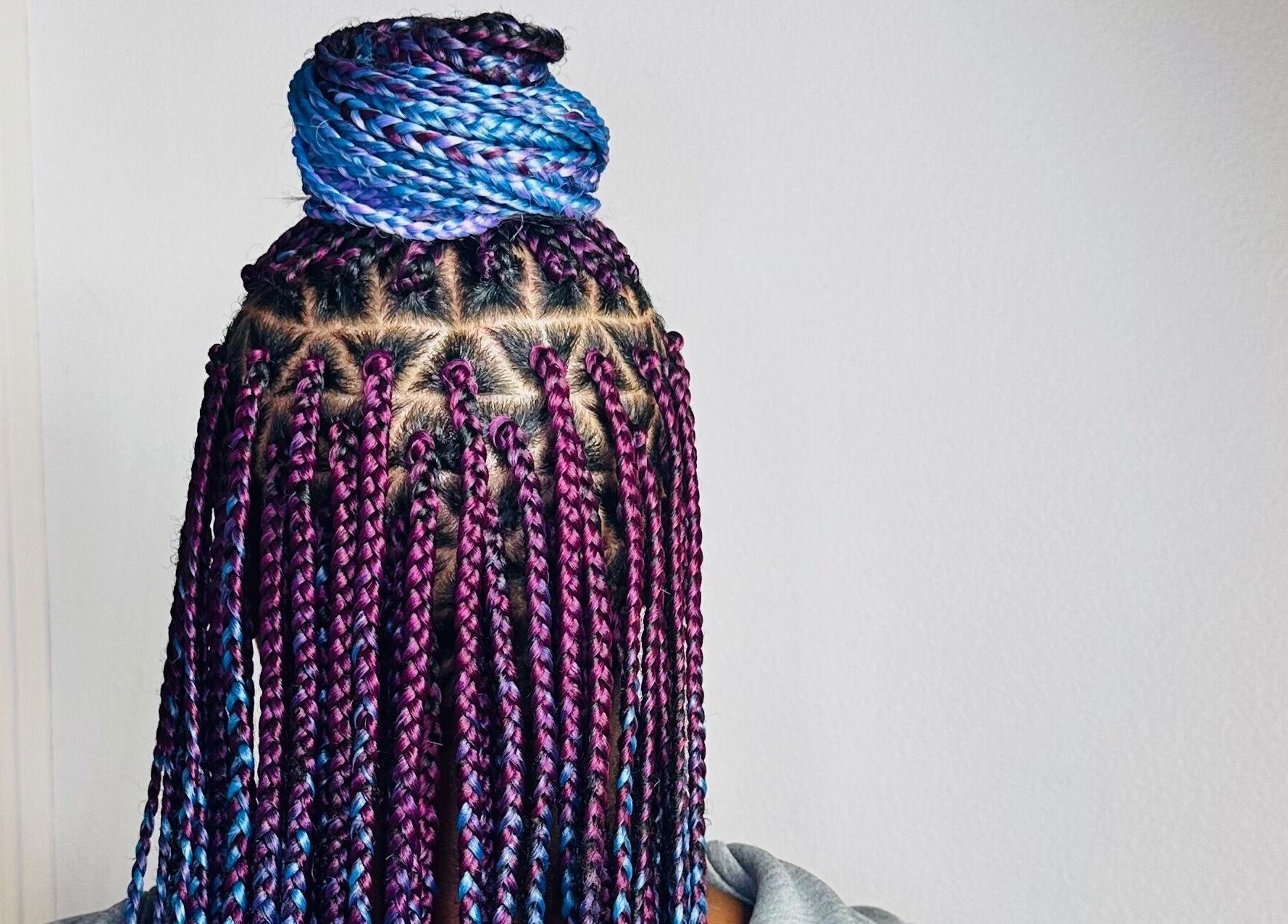 Vibrant braided hairstyle at Braids By Olma in Münsingen, Bern, CH. Purple and blue intricately styled braids.