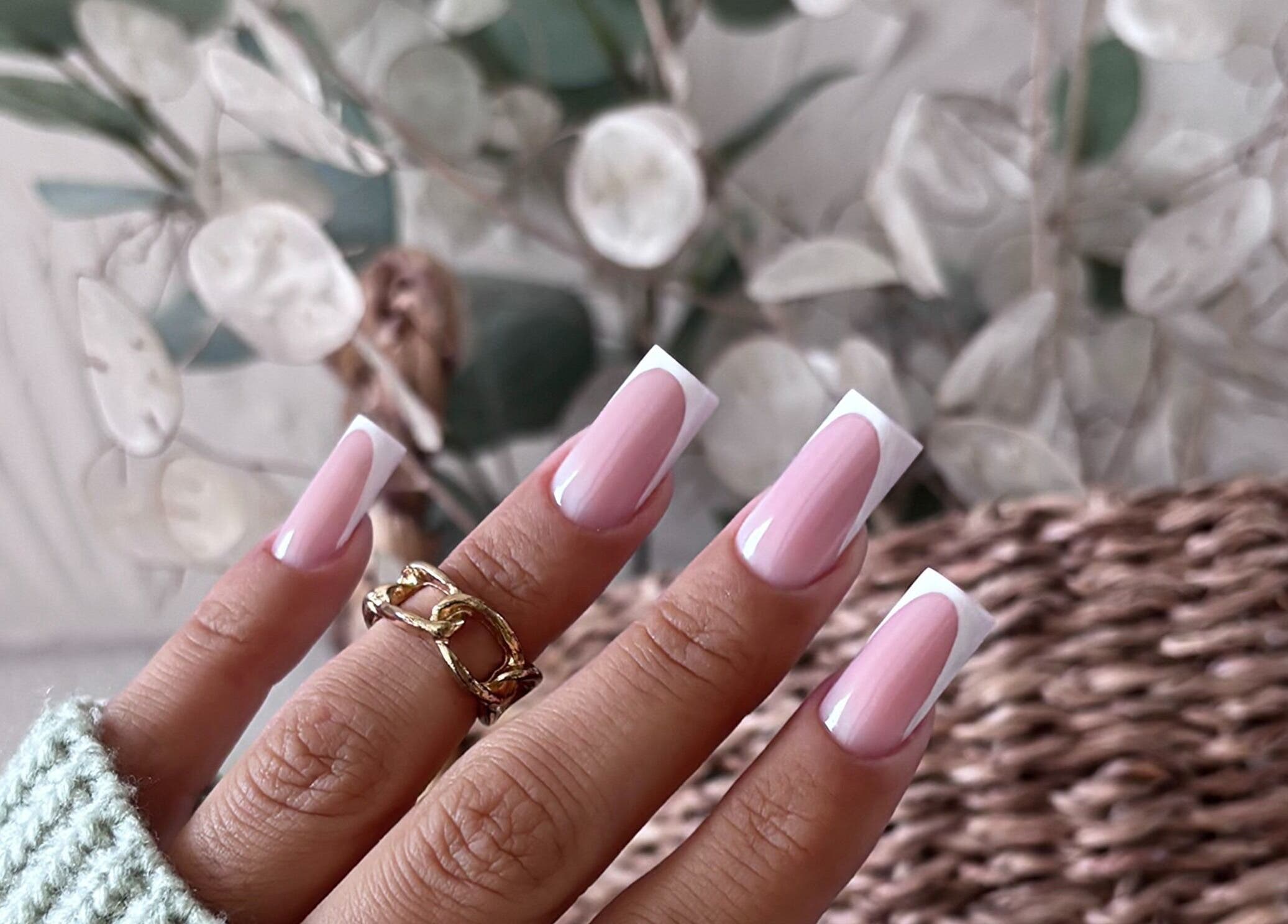 Manucure élégante à HOLA CHICAS, Laroque-d'olmes, Occitanie, FR, sur fond de fleurs blanches.