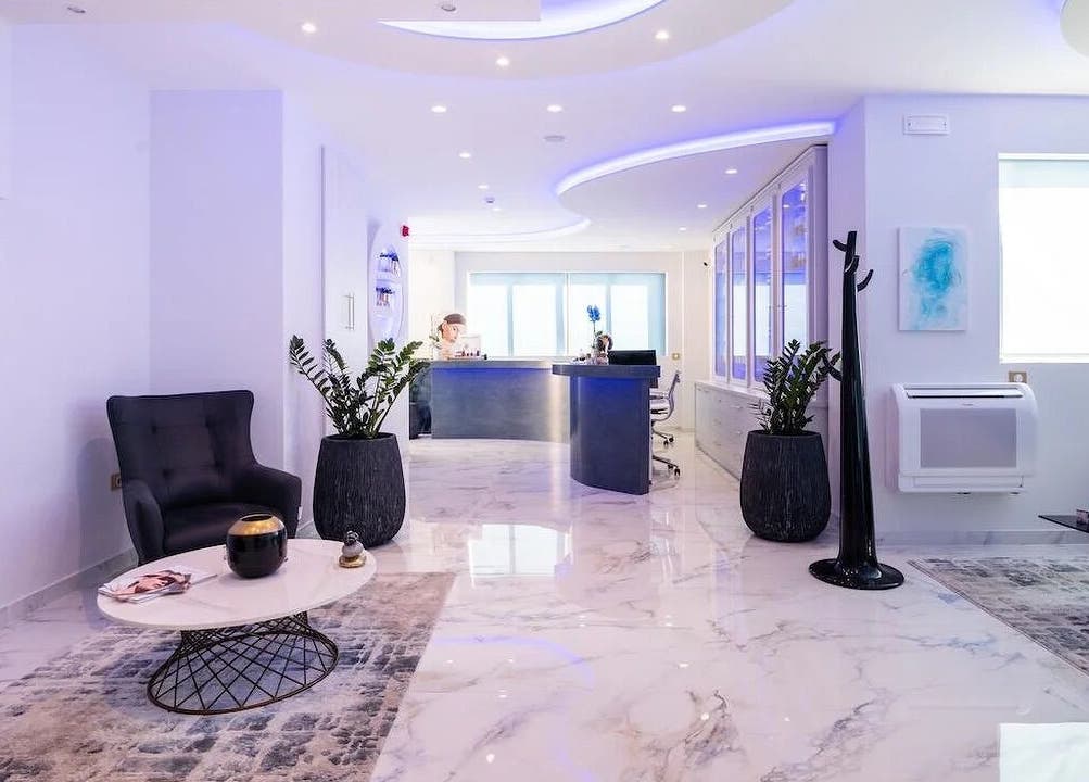 Σύγχρονη αίθουσα υποδοχής στο Laser Lina’s Clinic Center, Ηράκλειο, GR με μαρμάρινο πάτωμα και άνετες καρέκλες.