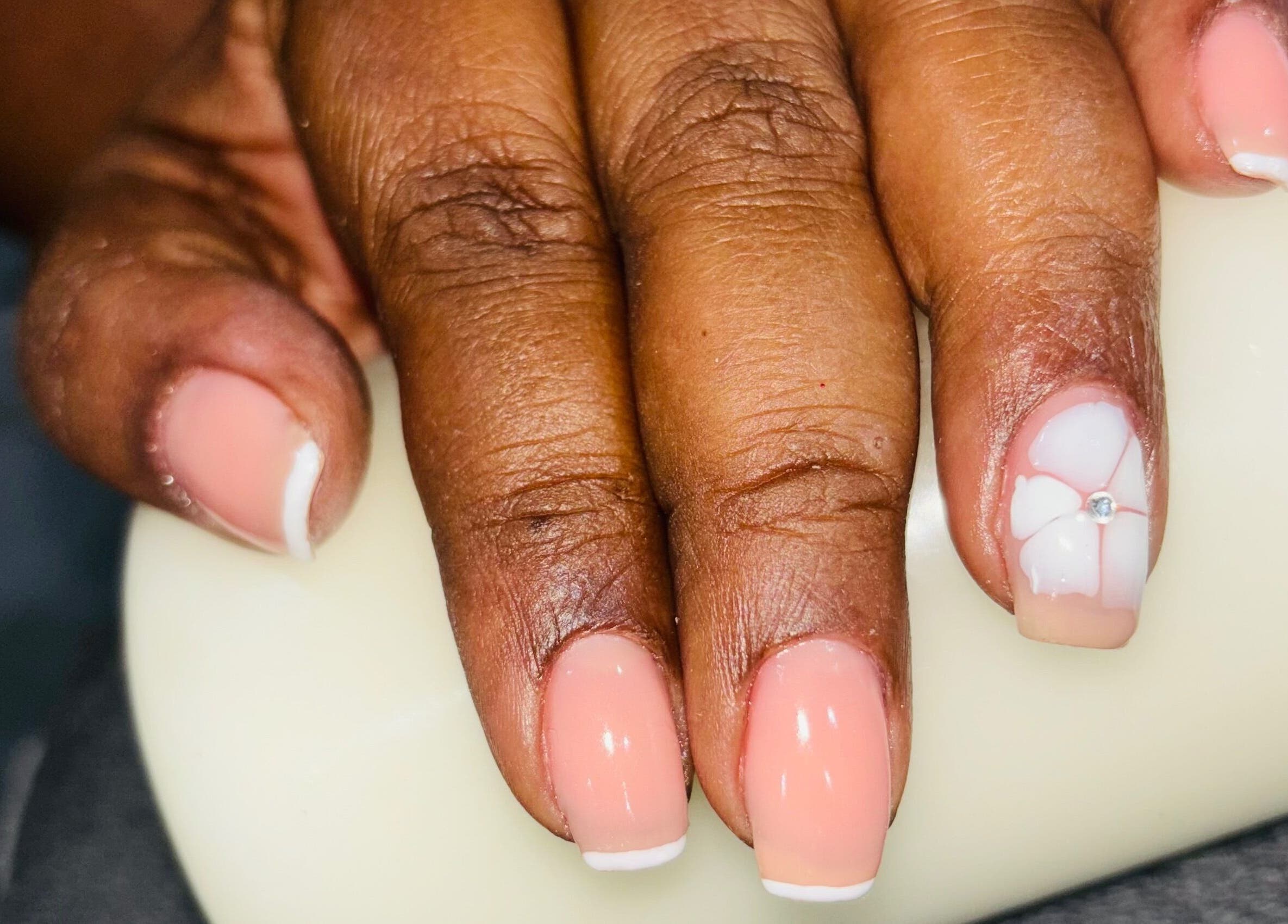Elegant nude nails with a floral design by Nails by Nelz in Alberton, Gauteng, ZA.