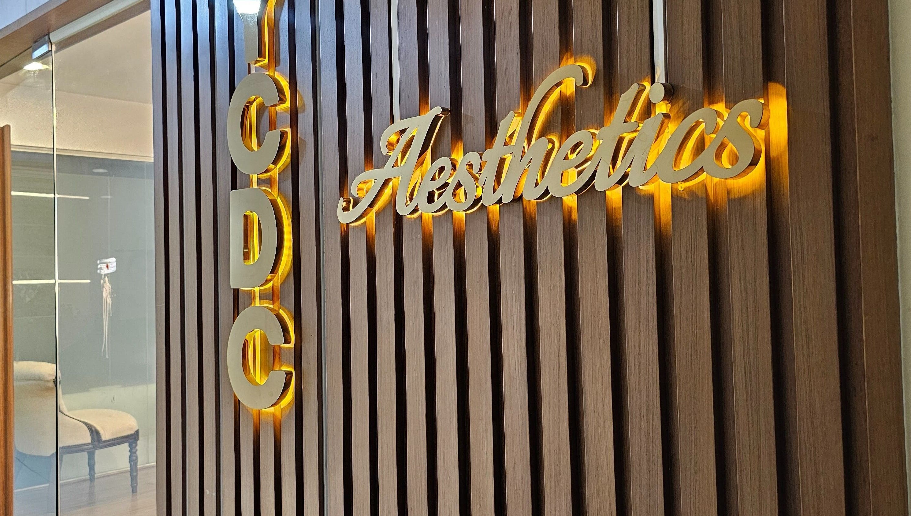 Entrance sign of YCDC THERAPISTS at Bengaluru, Karnataka, IN with wooden panel and illuminated letters.