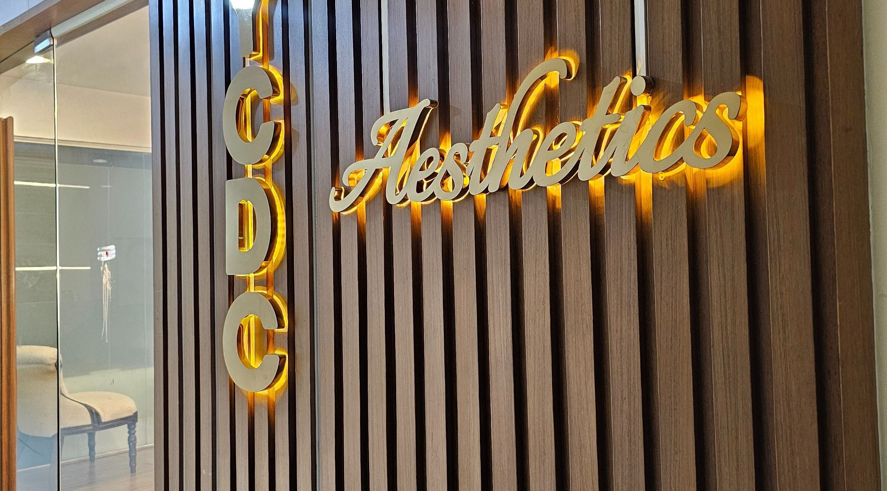 Entrance sign of YCDC THERAPISTS at Bengaluru, Karnataka, IN with wooden panel and illuminated letters.