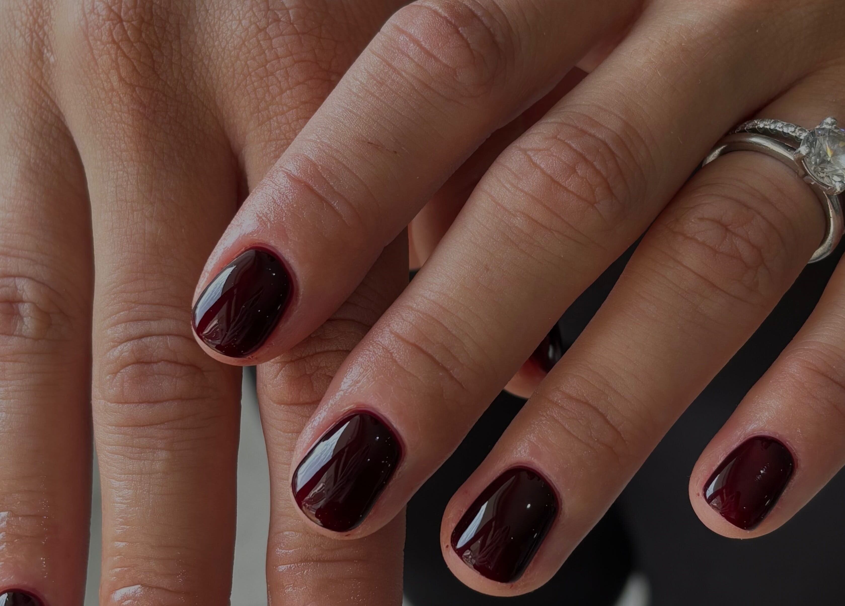 Elegant manicure with dark polish and diamond ring at with.jodes, Newhaven, England, GB.