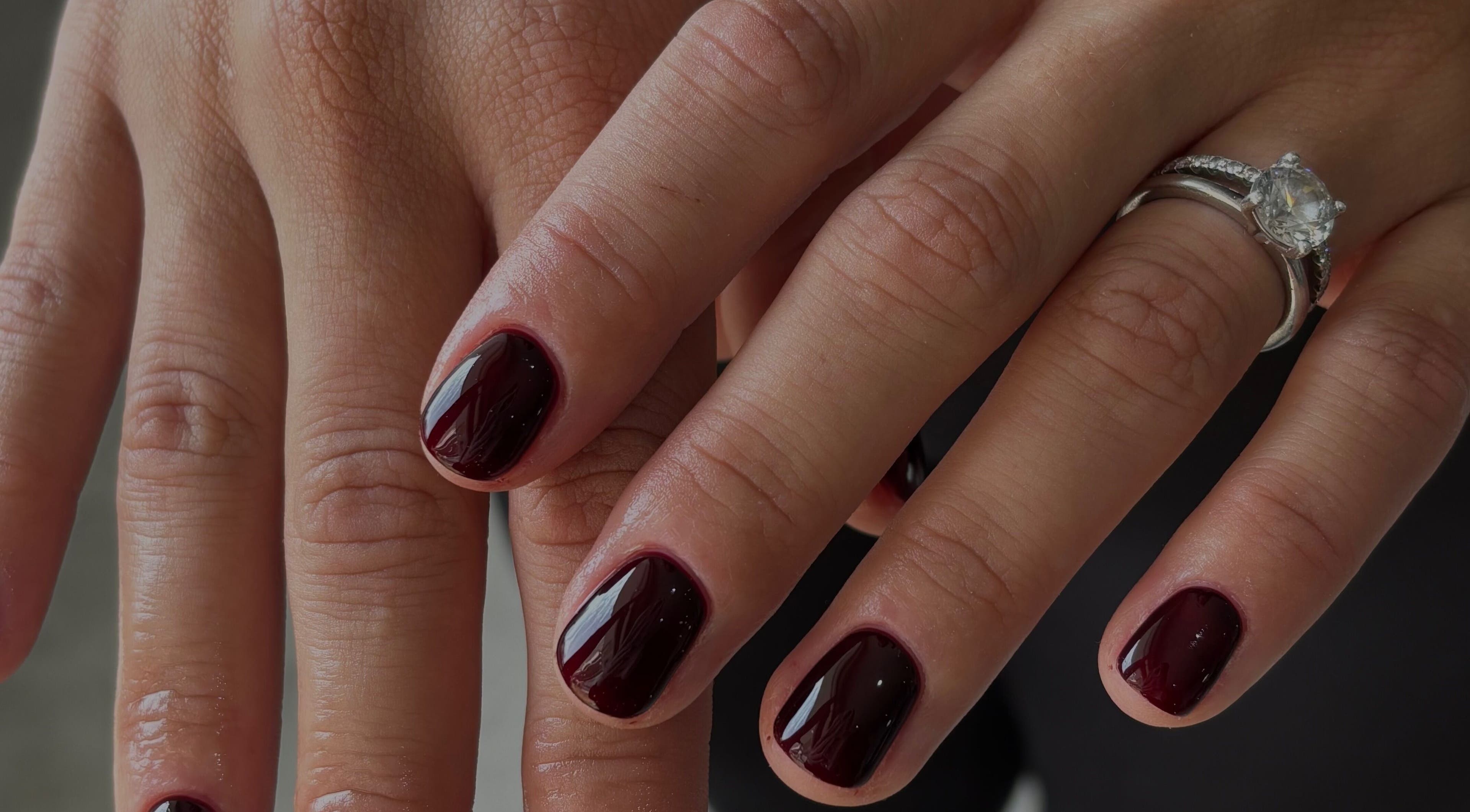 Elegant manicure with dark polish and diamond ring at with.jodes, Newhaven, England, GB.