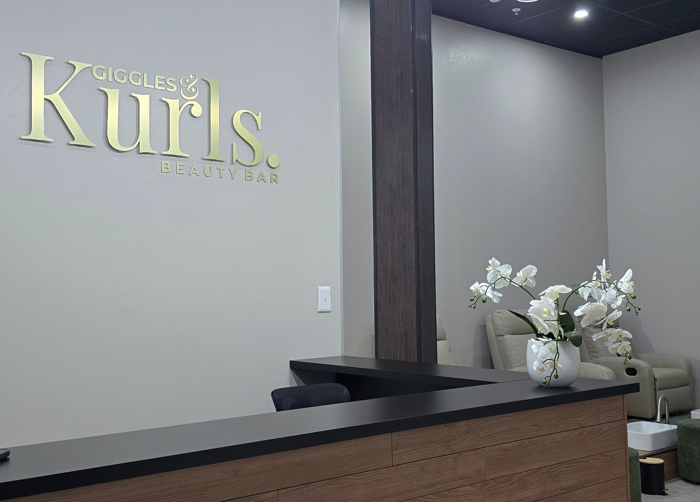 Reception area at Giggles n Kurls Clearwater in Roodepoort, Gauteng, ZA featuring modern decor with orchid.