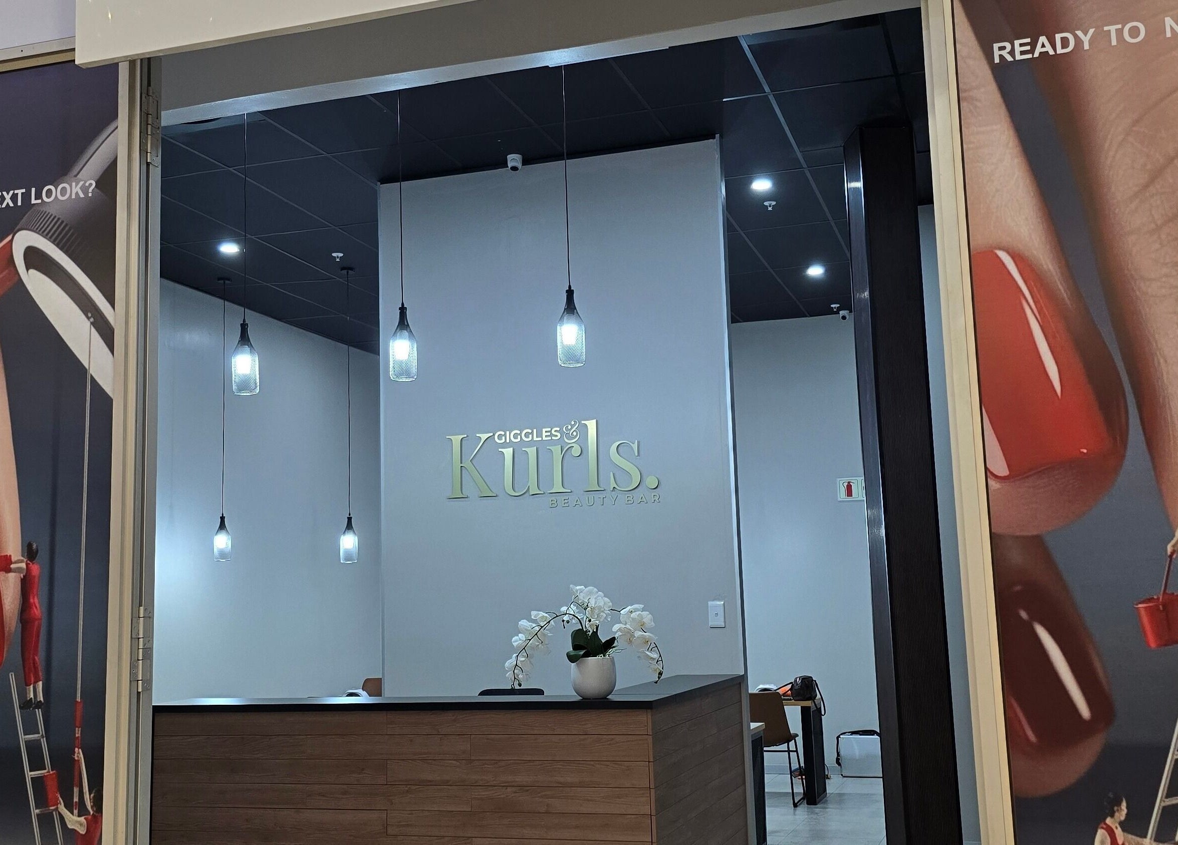 Entrance of Giggles n Kurls Clearwater in Roodepoort, Gauteng, ZA, with stylish interior and nail art posters.