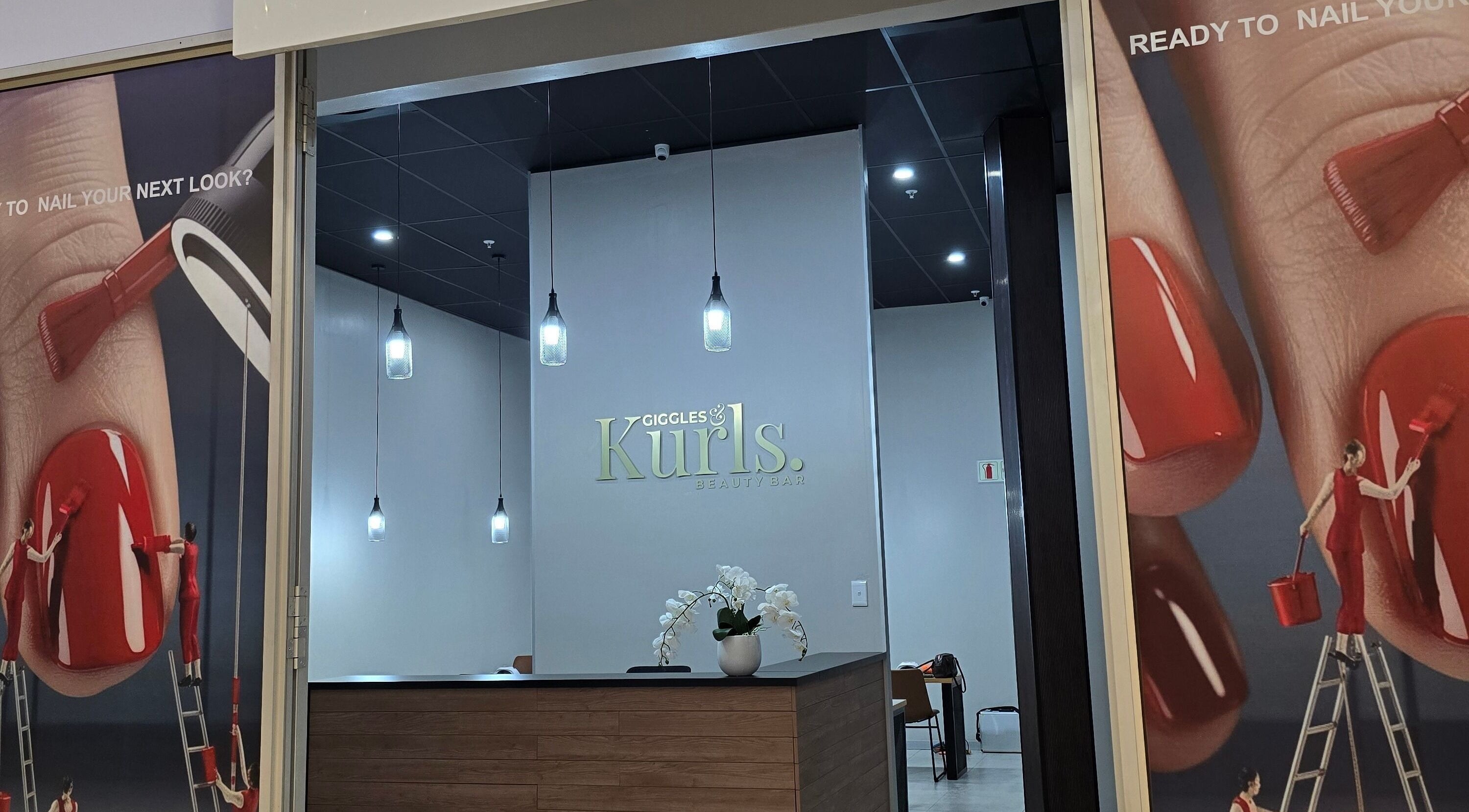 Entrance of Giggles n Kurls Clearwater in Roodepoort, Gauteng, ZA, with stylish interior and nail art posters.