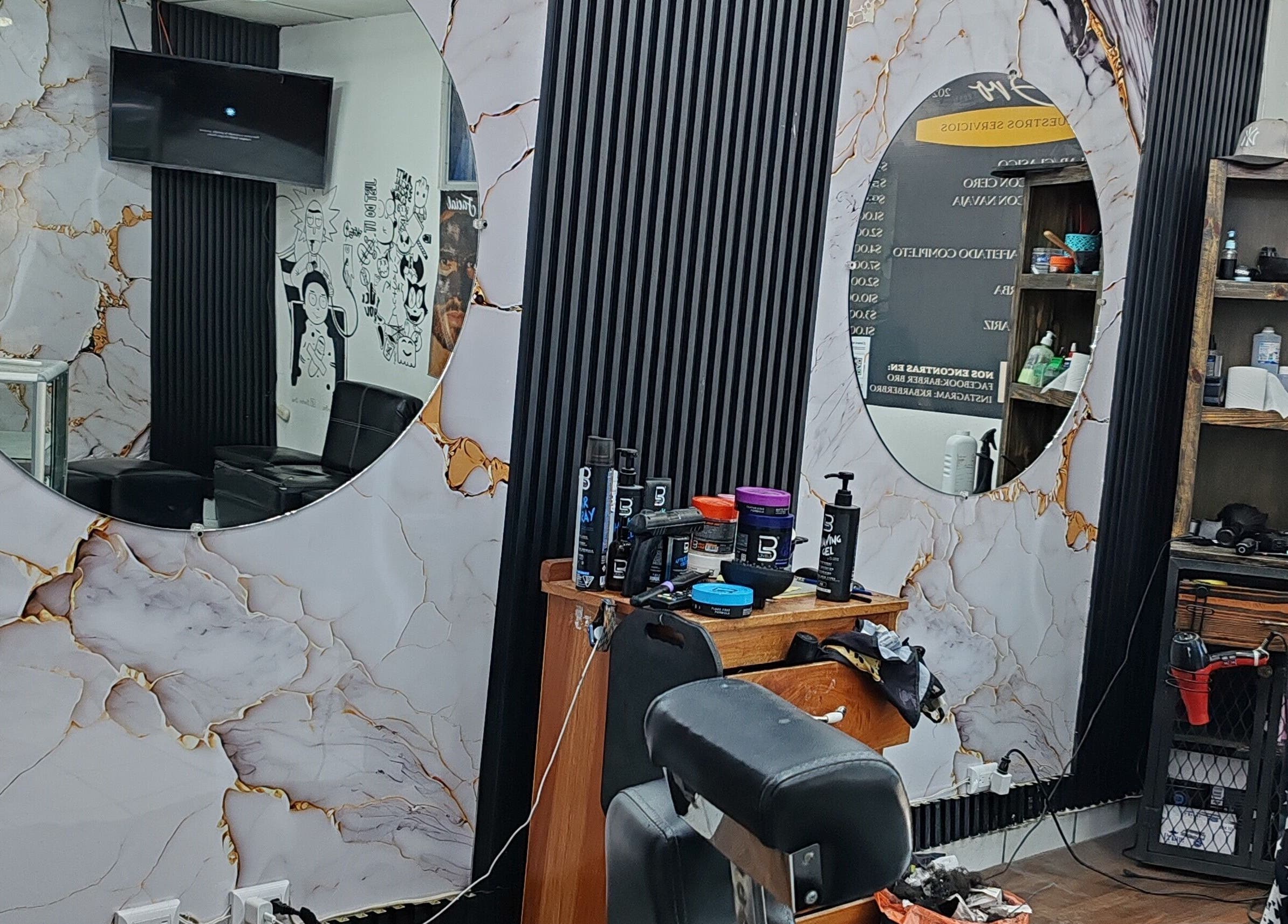 Interior elegante de JRobertoHB en La Libertad, SV con espejos circulares y productos de cuidado personal.