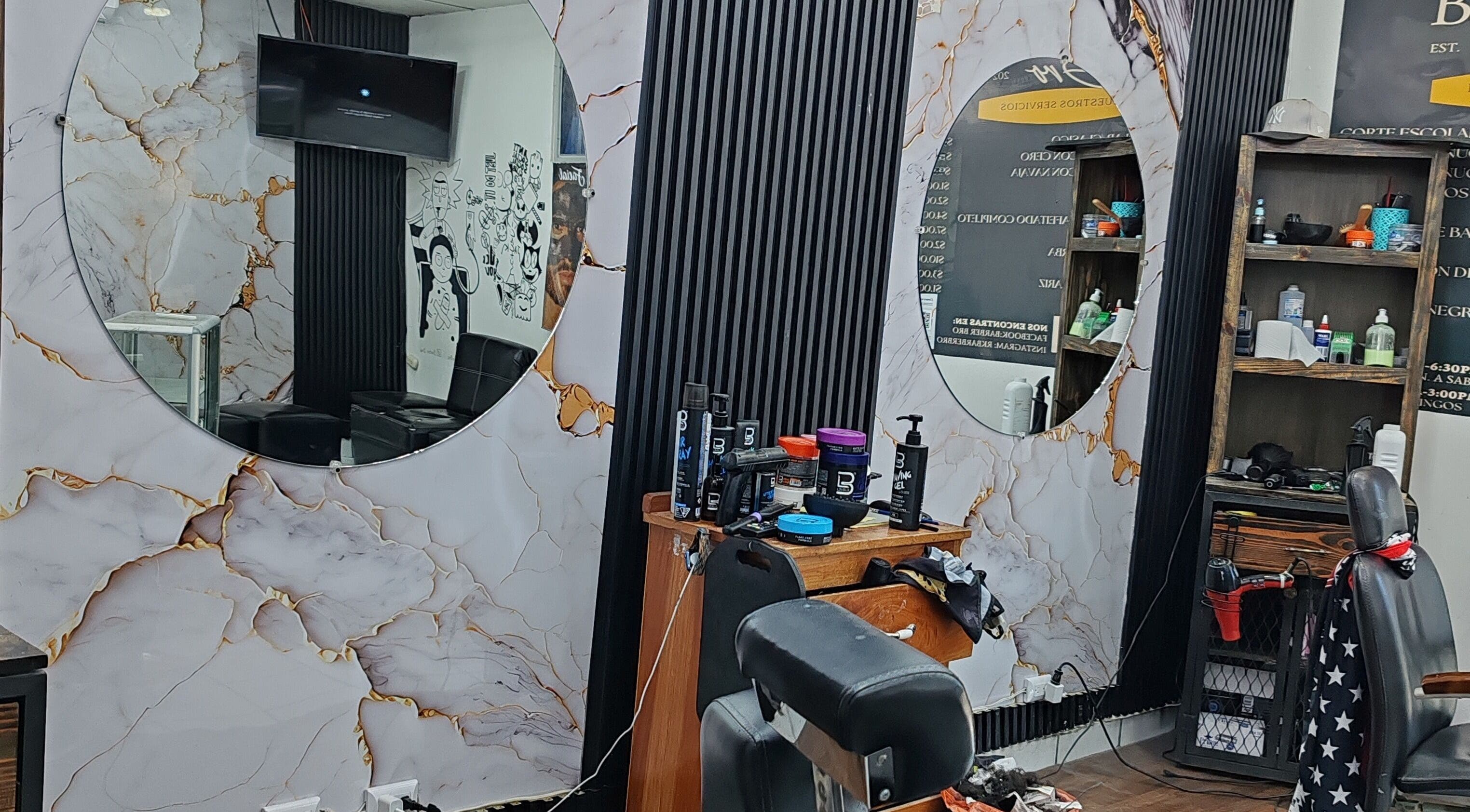 Interior elegante de JRobertoHB en La Libertad, SV con espejos circulares y productos de cuidado personal.