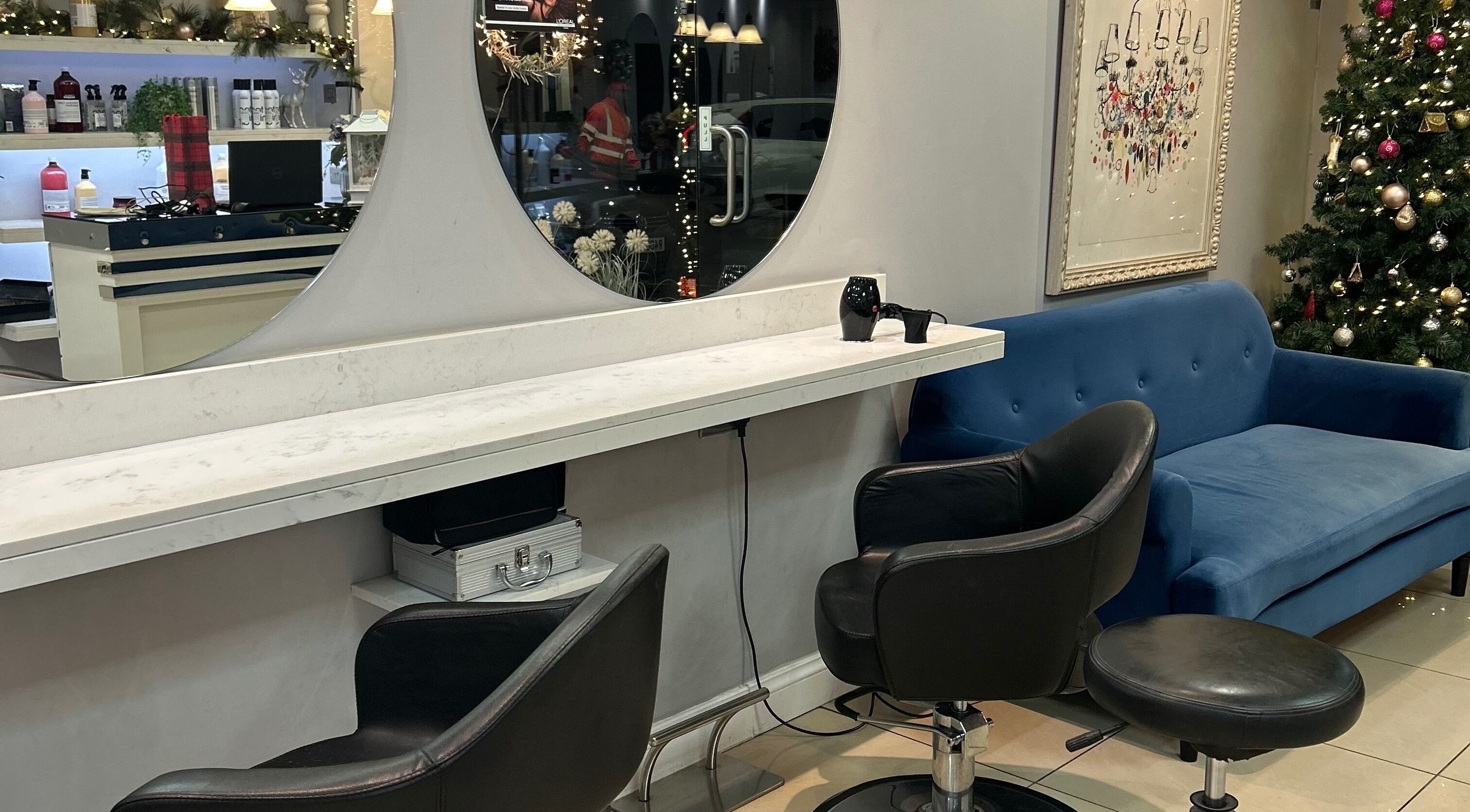 PGeorgiou - Hairdresser's stylish interior with blue sofa and holiday decor, Worcester Park, England, GB.