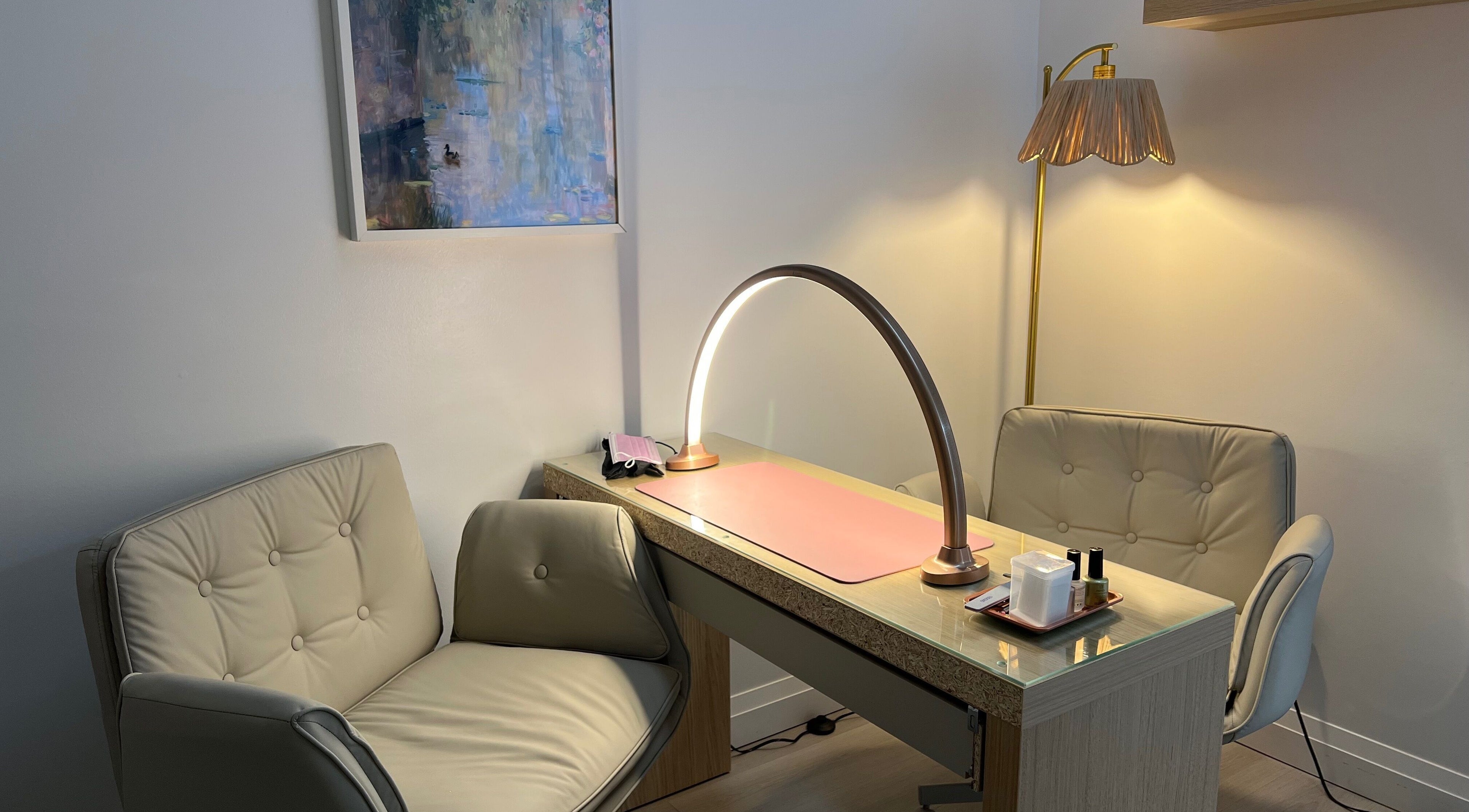 Elegant nail service area at The Glossy Garden, Hamilton, Ontario, CA with cozy chairs and modern lighting.