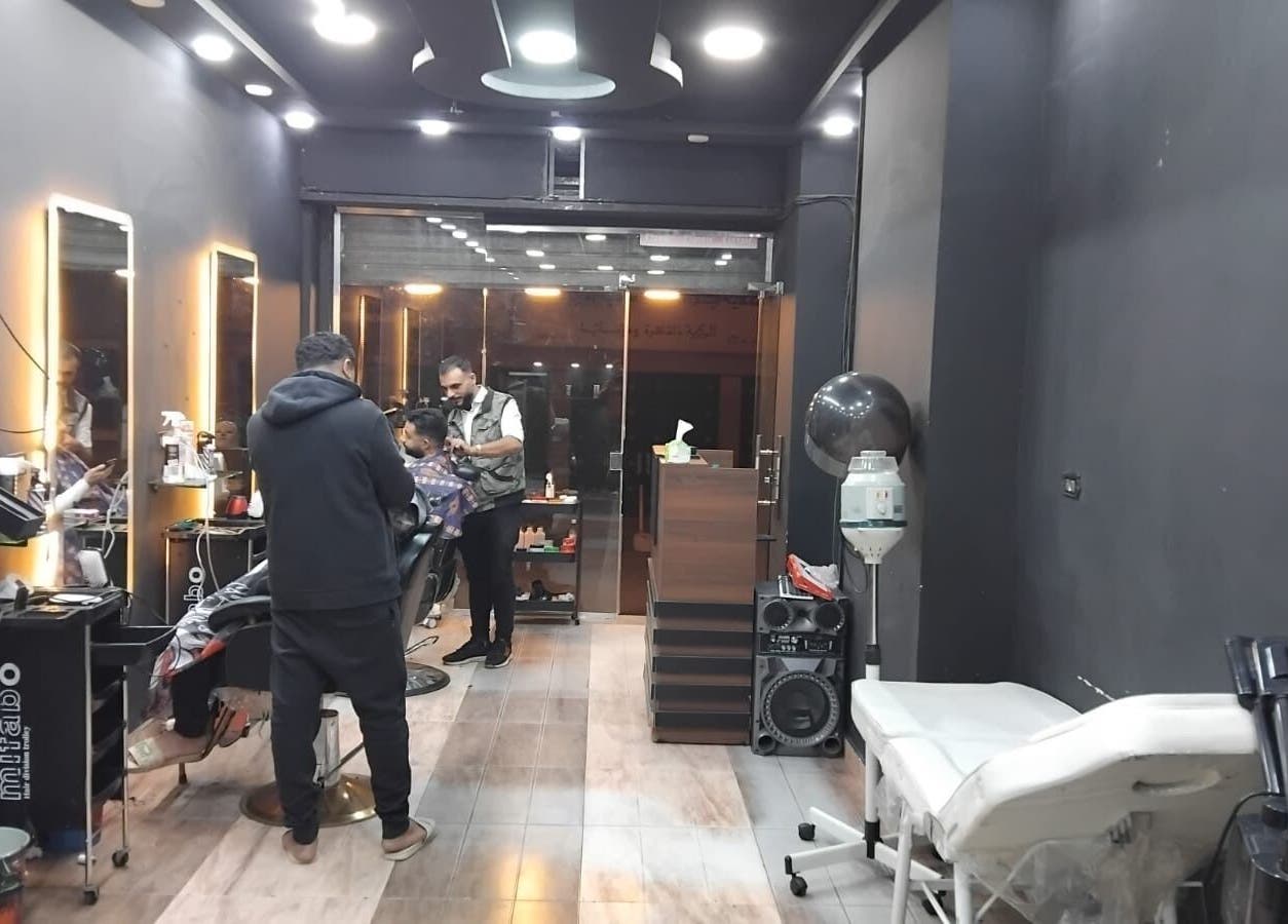 Modern salon interior at Haircut in Cairo Governorate, showcasing styling stations and cozy ambiance.