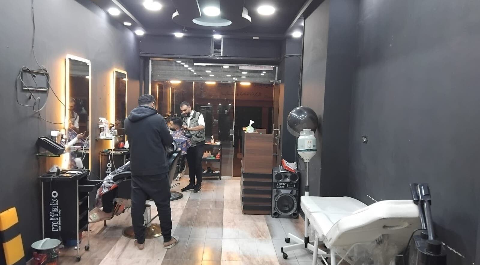Modern salon interior at Haircut in Cairo Governorate, showcasing styling stations and cozy ambiance.