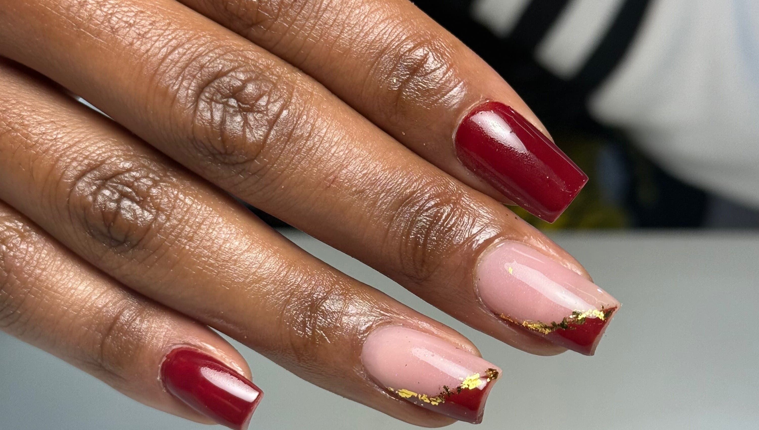 Stylish red and pink nails with gold accents at Hadisnail in Budapest, Magyar, HU.