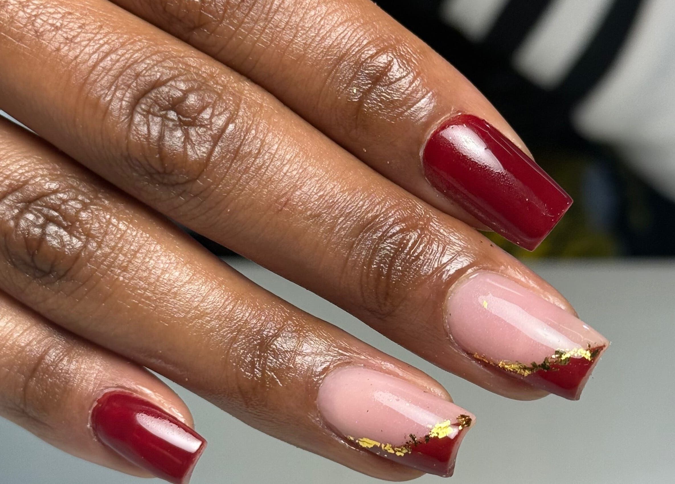 Stylish red and pink nails with gold accents at Hadisnail in Budapest, Magyar, HU.