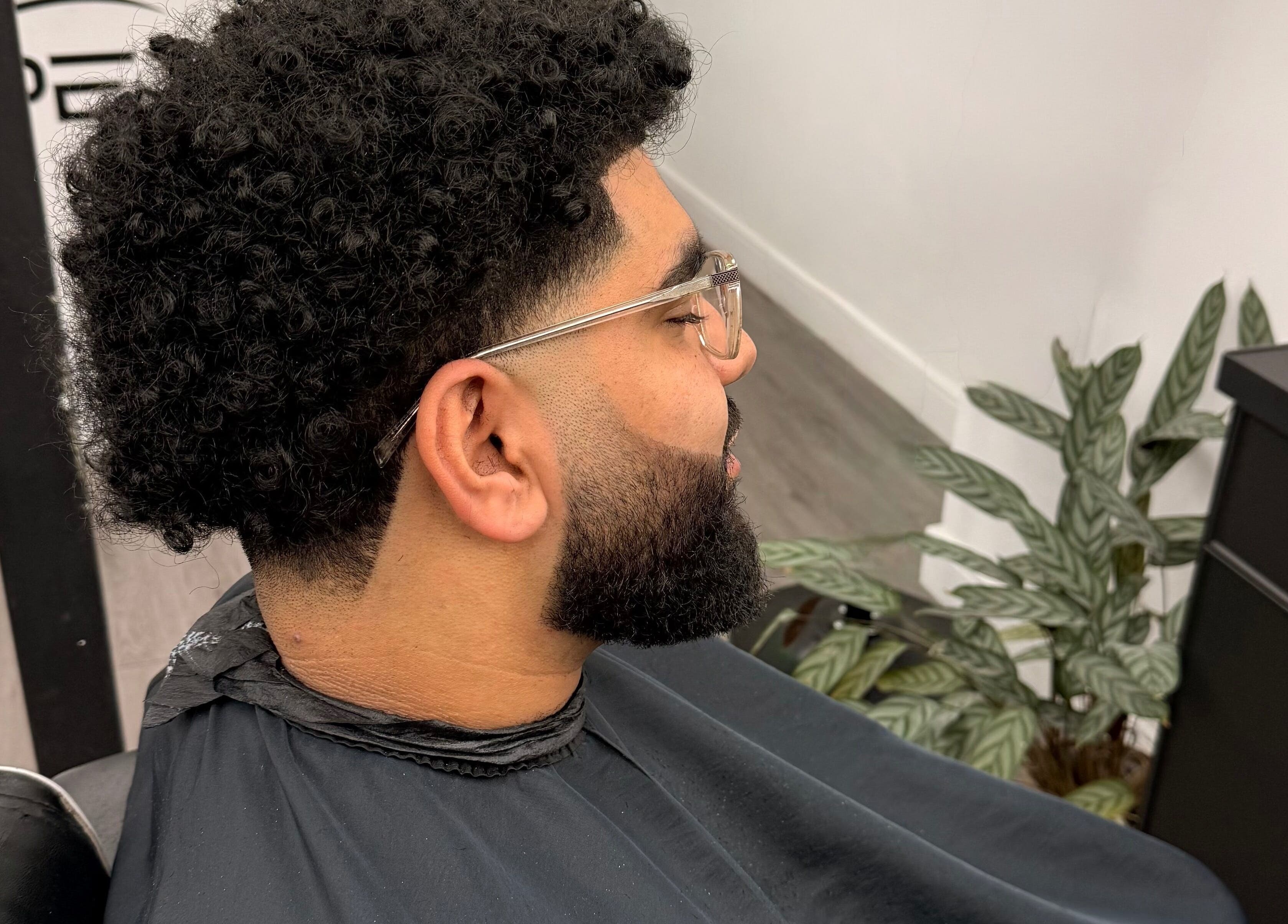 Man with a fresh curly haircut at Dramz Cutz in Brighton And Hove, England, GB.