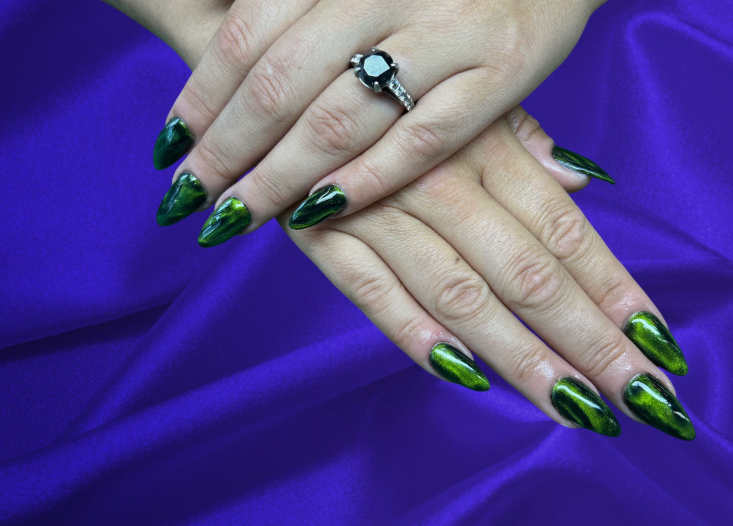 Green glossy nails at The Nail Cabin - Muskoka, Huntsville, Ontario, CA on purple silk fabric.