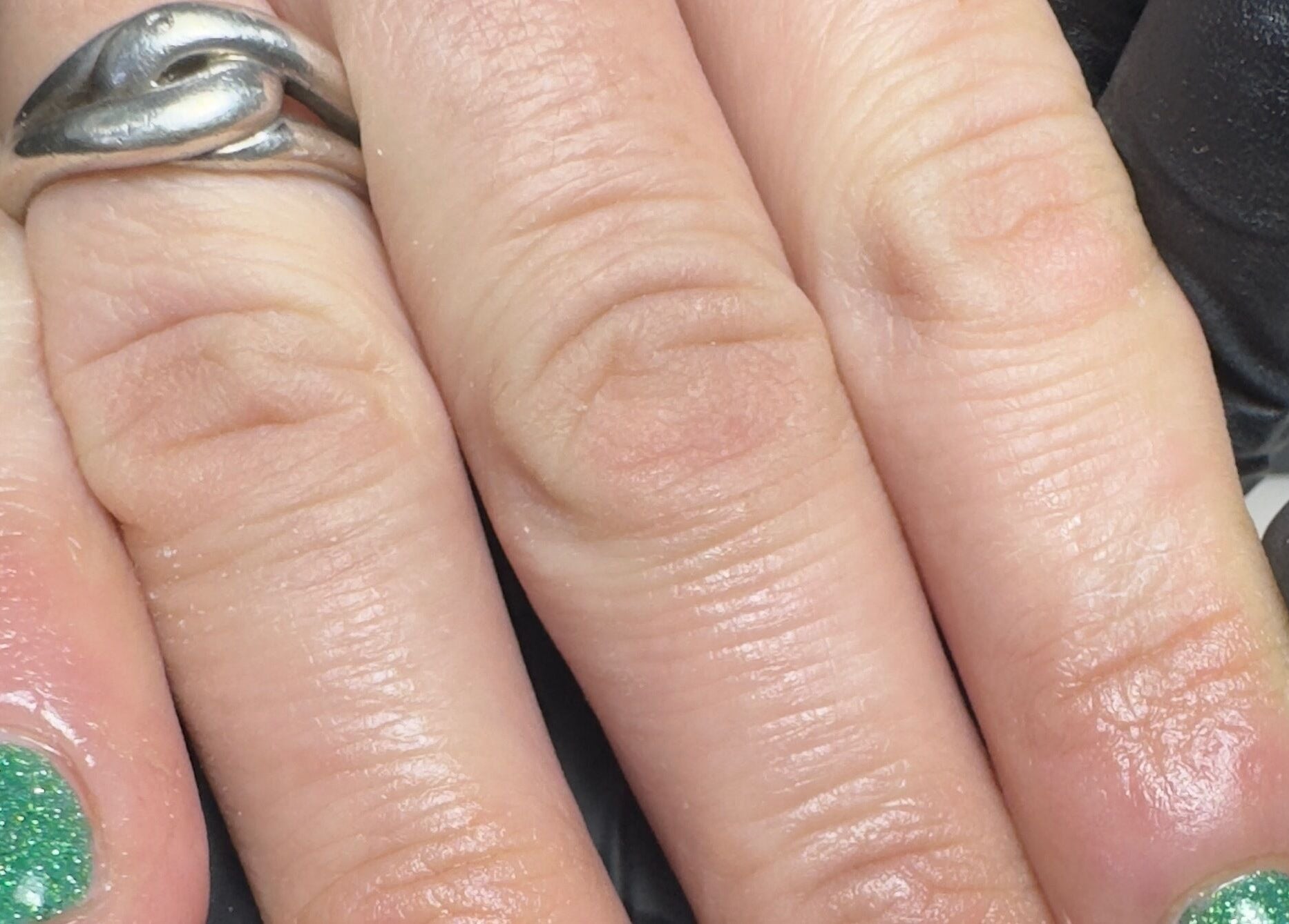 Green glitter nails with a silver ring at BIAB beauty bar, Bradwell, England, GB.