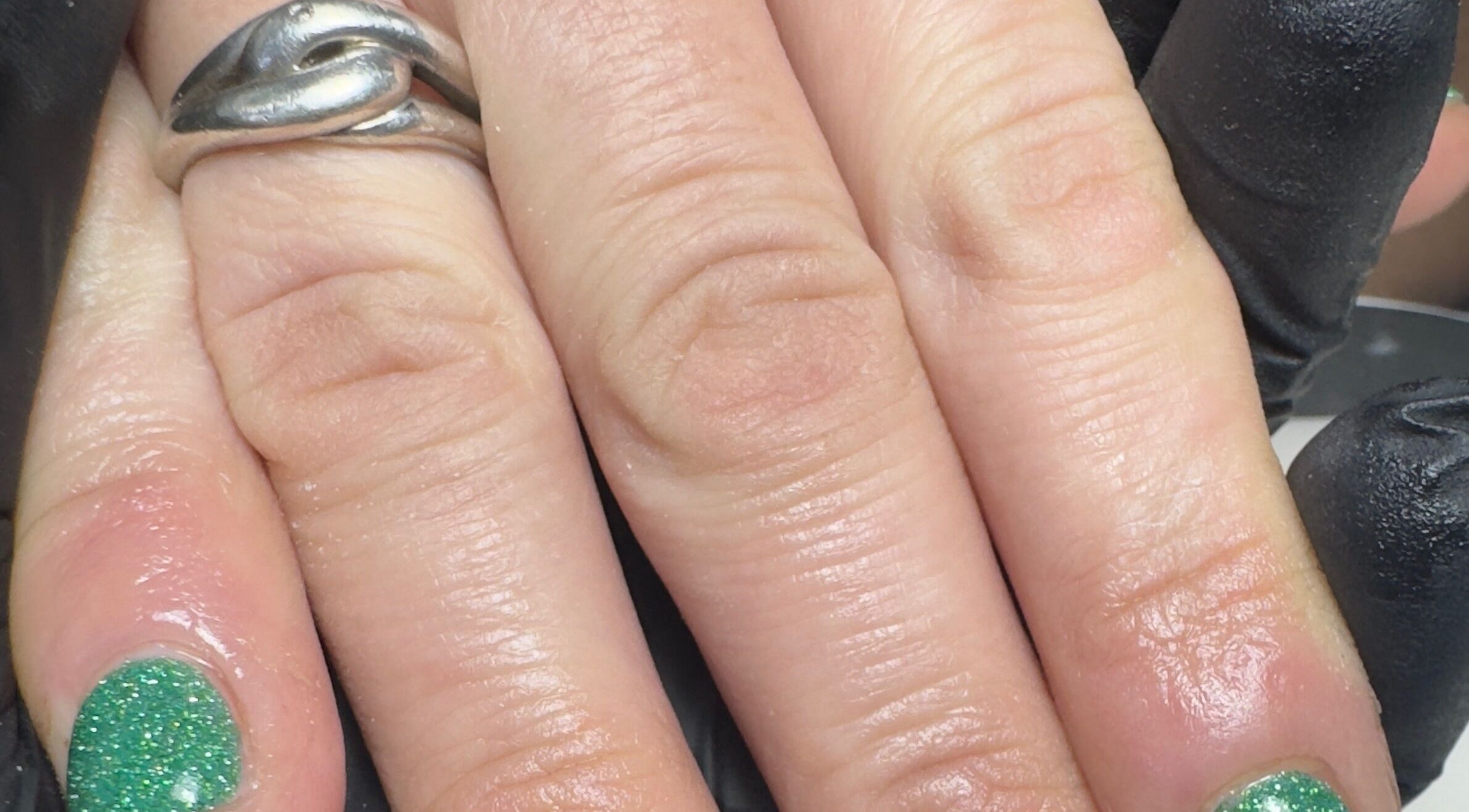 Green glitter nails with a silver ring at BIAB beauty bar, Bradwell, England, GB.