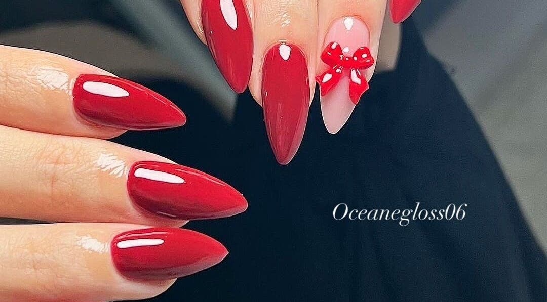 Manucure élégante en rouge avec nœud art à Oceanegloss, Nice, Provence-alpes-côte D'azur, FR.