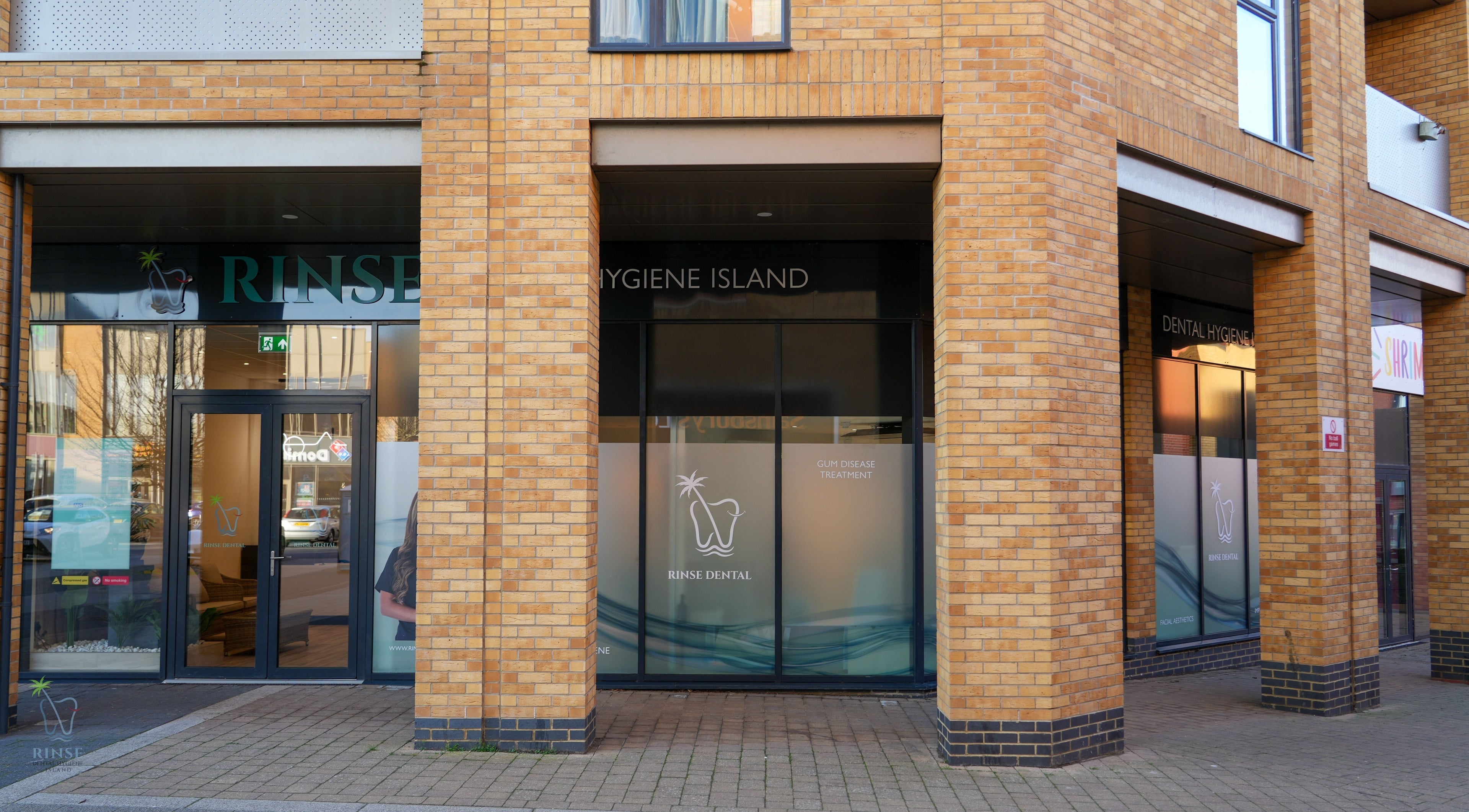 Entrance of Rinse Dental Hygiene Island in Milton Keynes, England, showcasing modern glass facade.