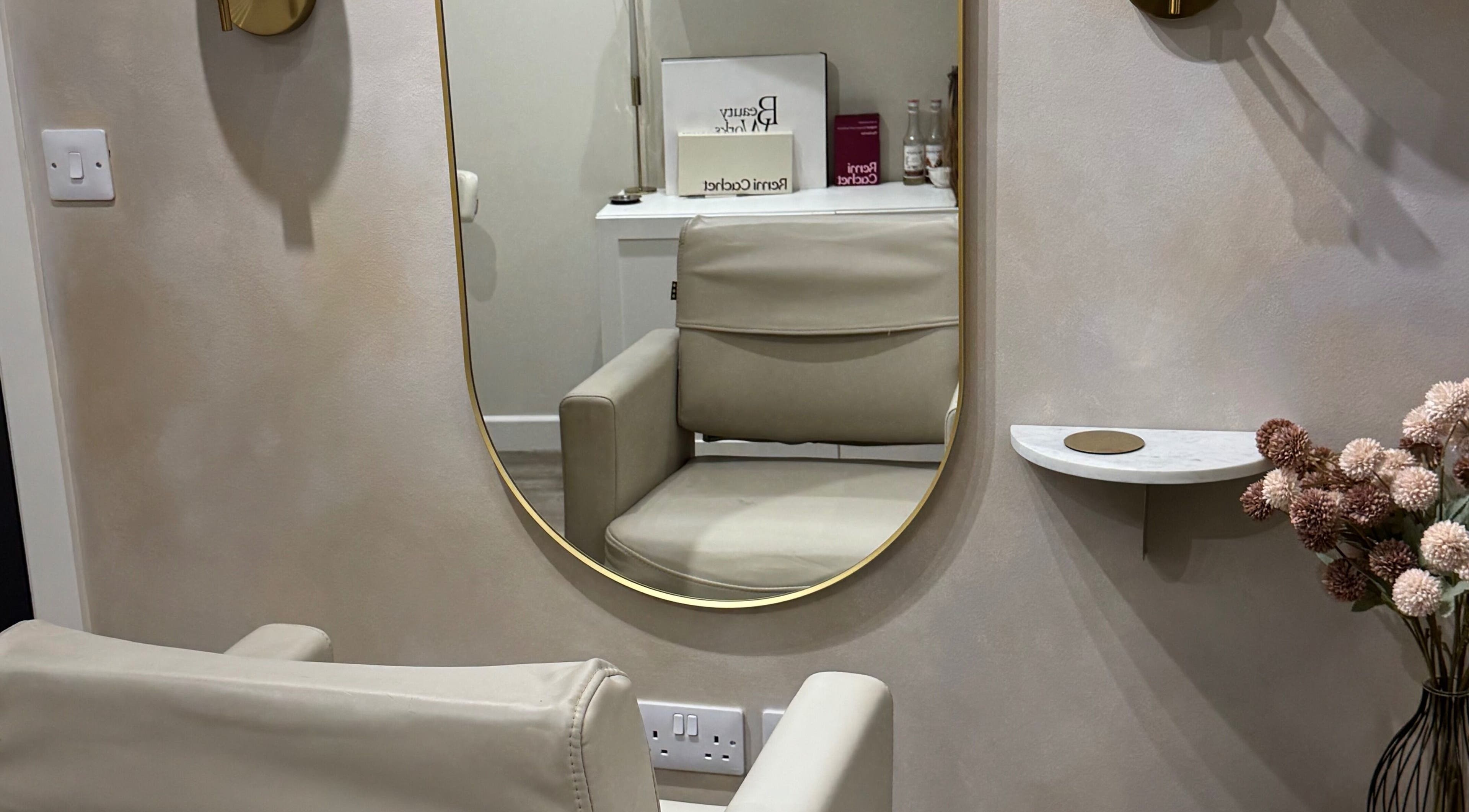 Luxurious salon chair and mirror at Aidan Steele Hair in Warwick, England, GB, reflecting a modern, serene space.