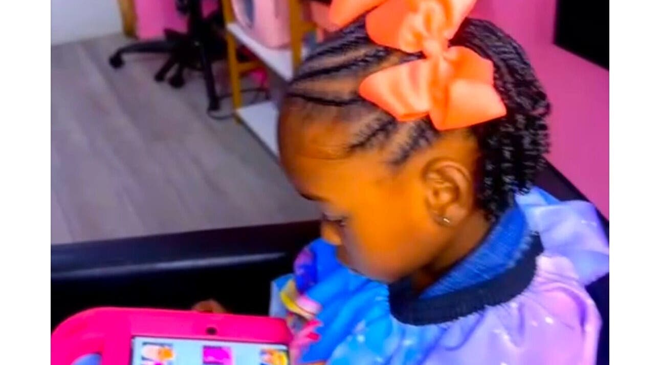 Child with braided hair and orange bow at The Braiding Parlor, Nassau, New Providence, BS.